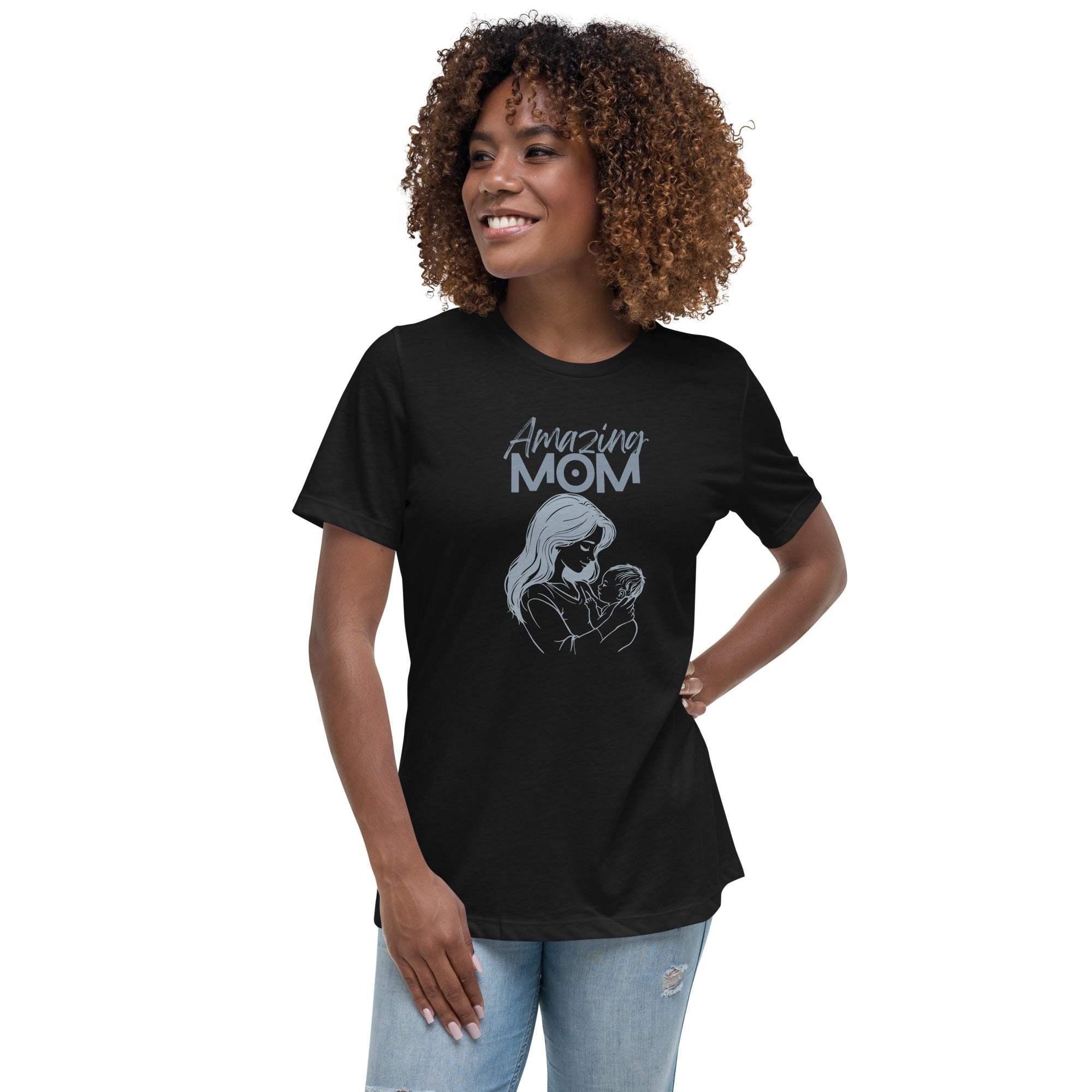Black Amazing Mom T-Shirt with a graphic of a mother holding a baby, worn by a smiling woman with curly hair.