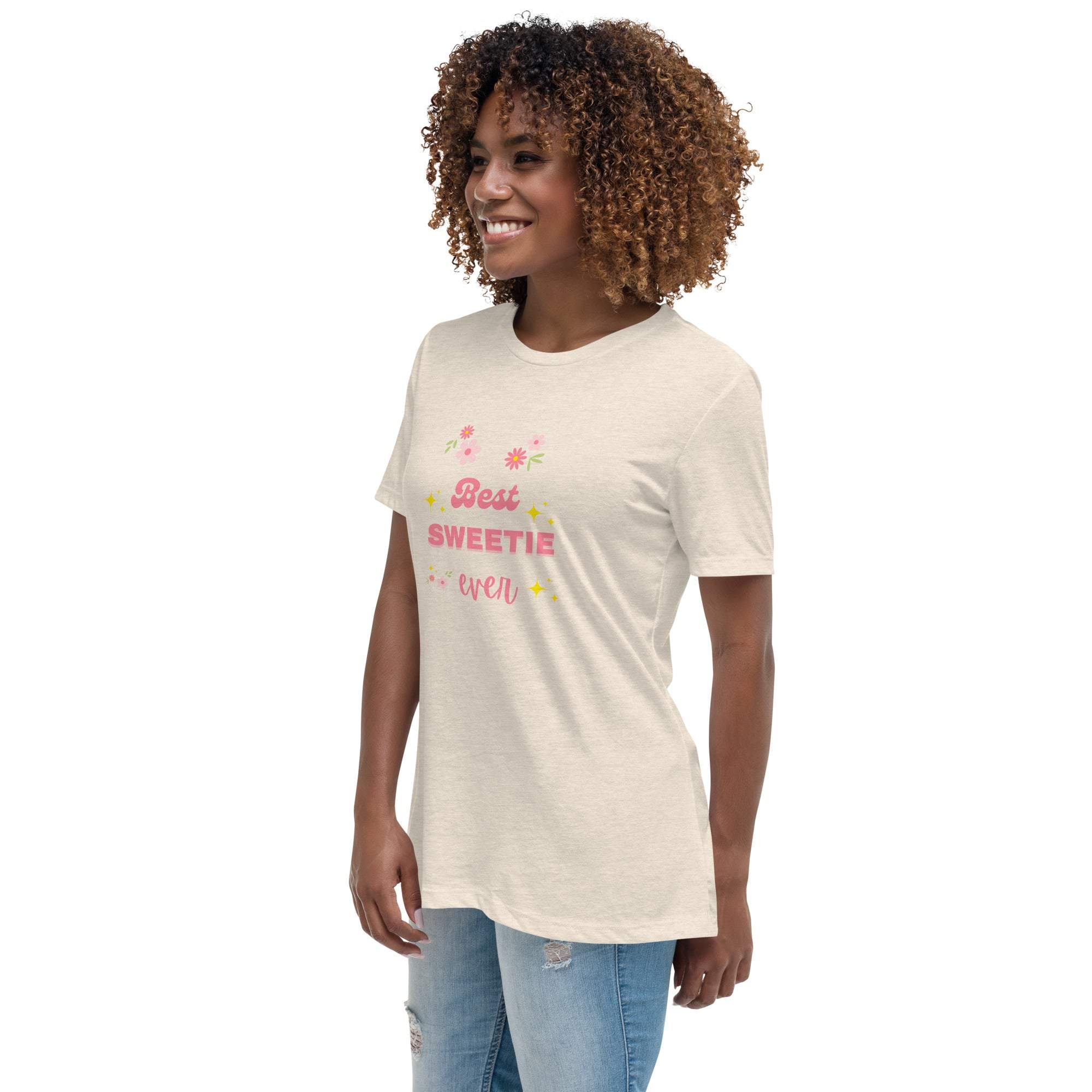 Woman wearing a beige "Best Sweetie Ever" t-shirt with floral and star designs, paired with light blue jeans