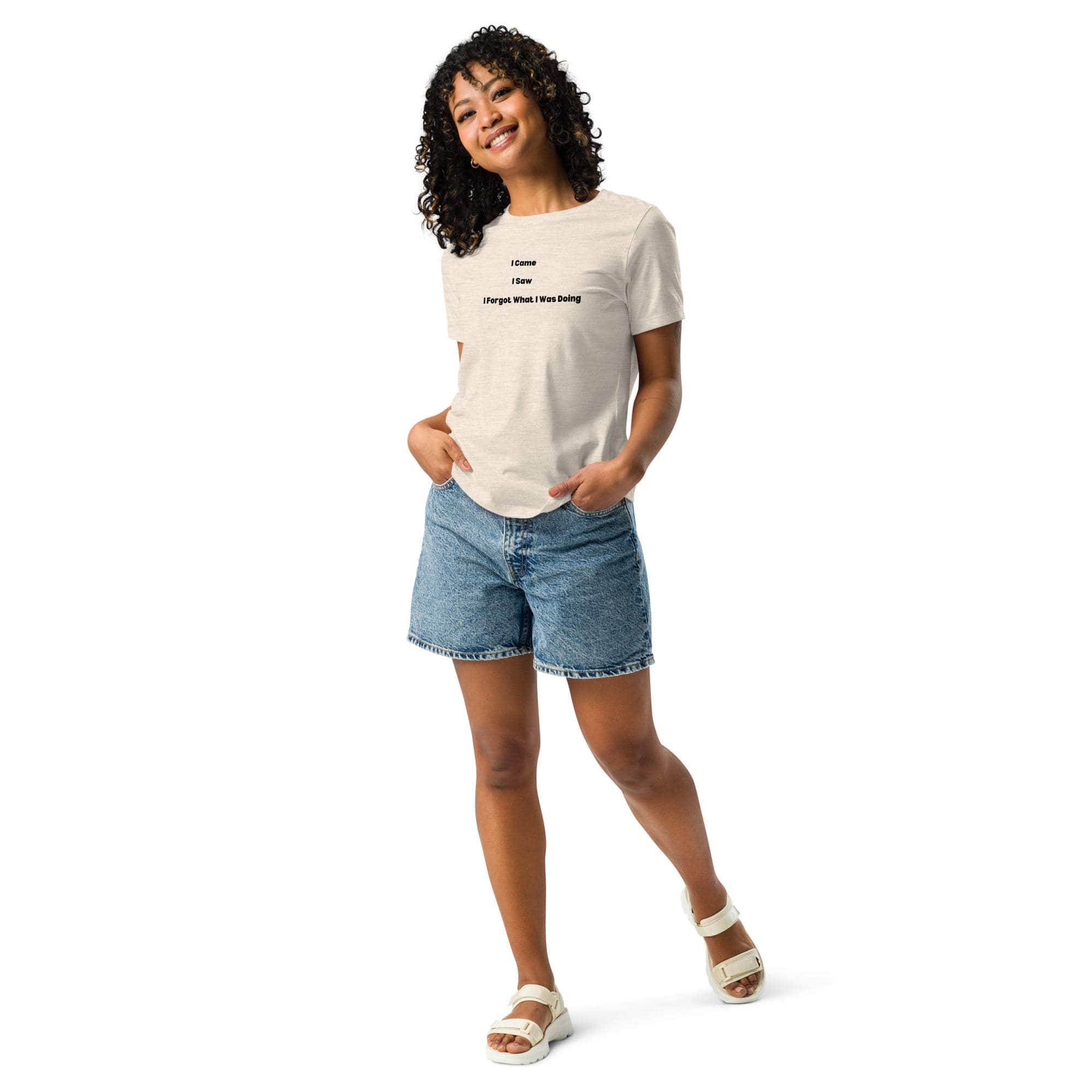 Woman wearing a casual beige t-shirt with the sarcastic phrase "I Came, I Saw, I Forgot What I Was Doing" paired with denim shorts and white sandals.