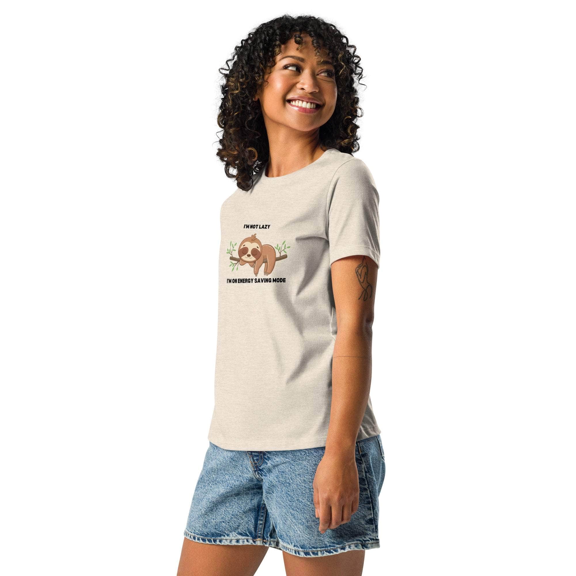 Woman wearing beige "I'm Not Lazy, I am On Energy Saving Mode" sloth graphic T-shirt with denim shorts
