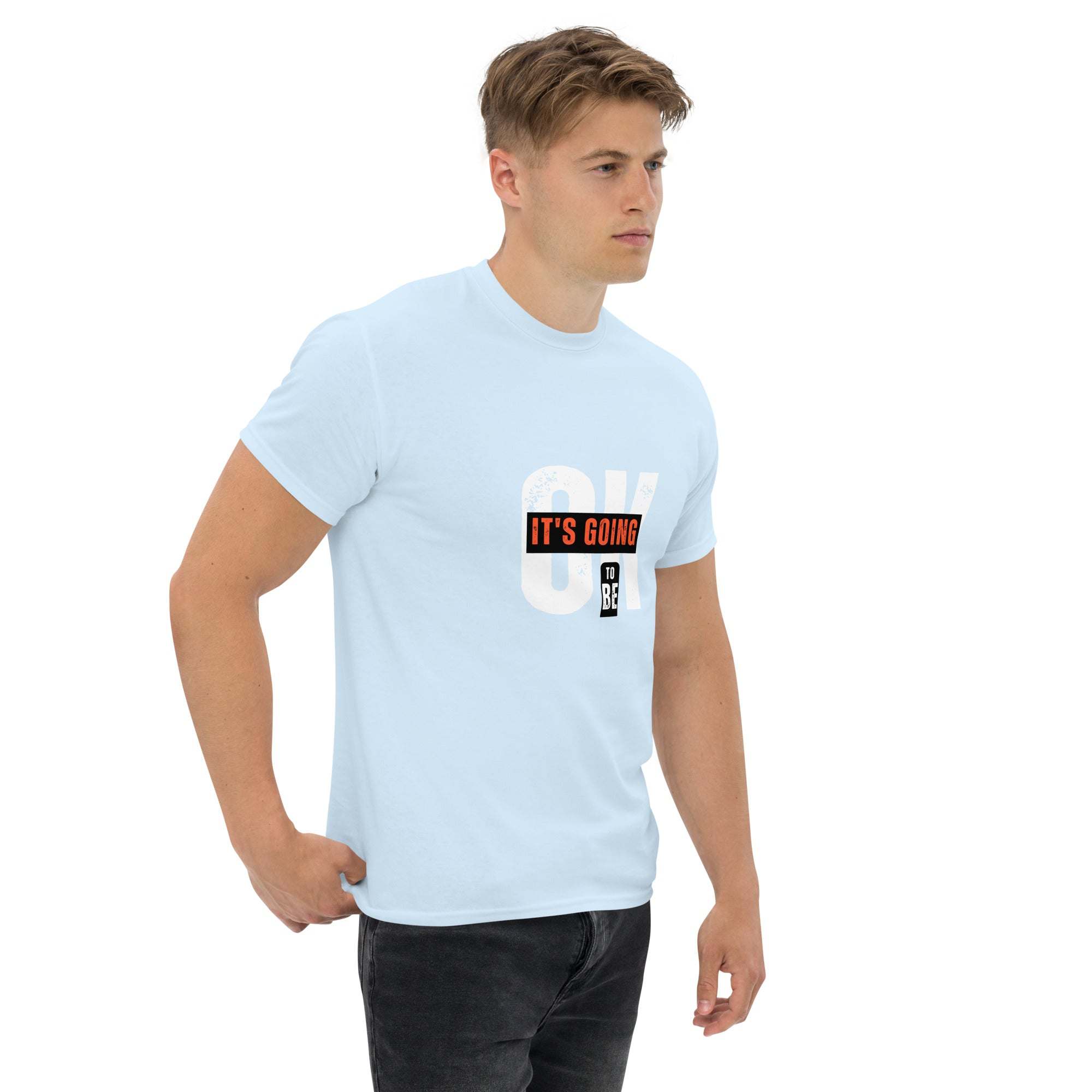 Male model wearing a light blue trendy graphic t-shirt with motivational quote on front, paired with black jeans.