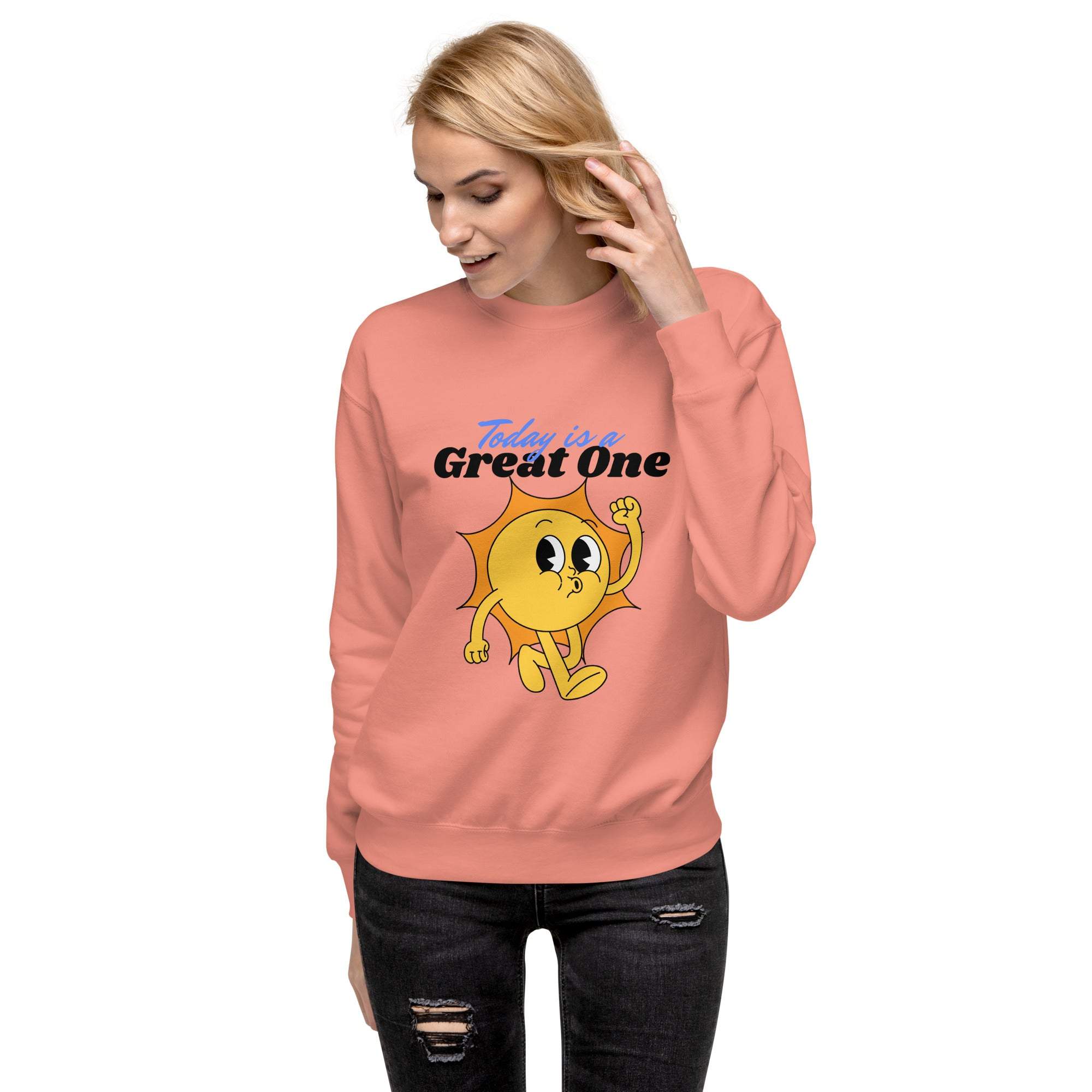 Woman wearing a coral Positive Sun Sweatshirt with a cheerful sun graphic and motivational text "Today is a Great One"
