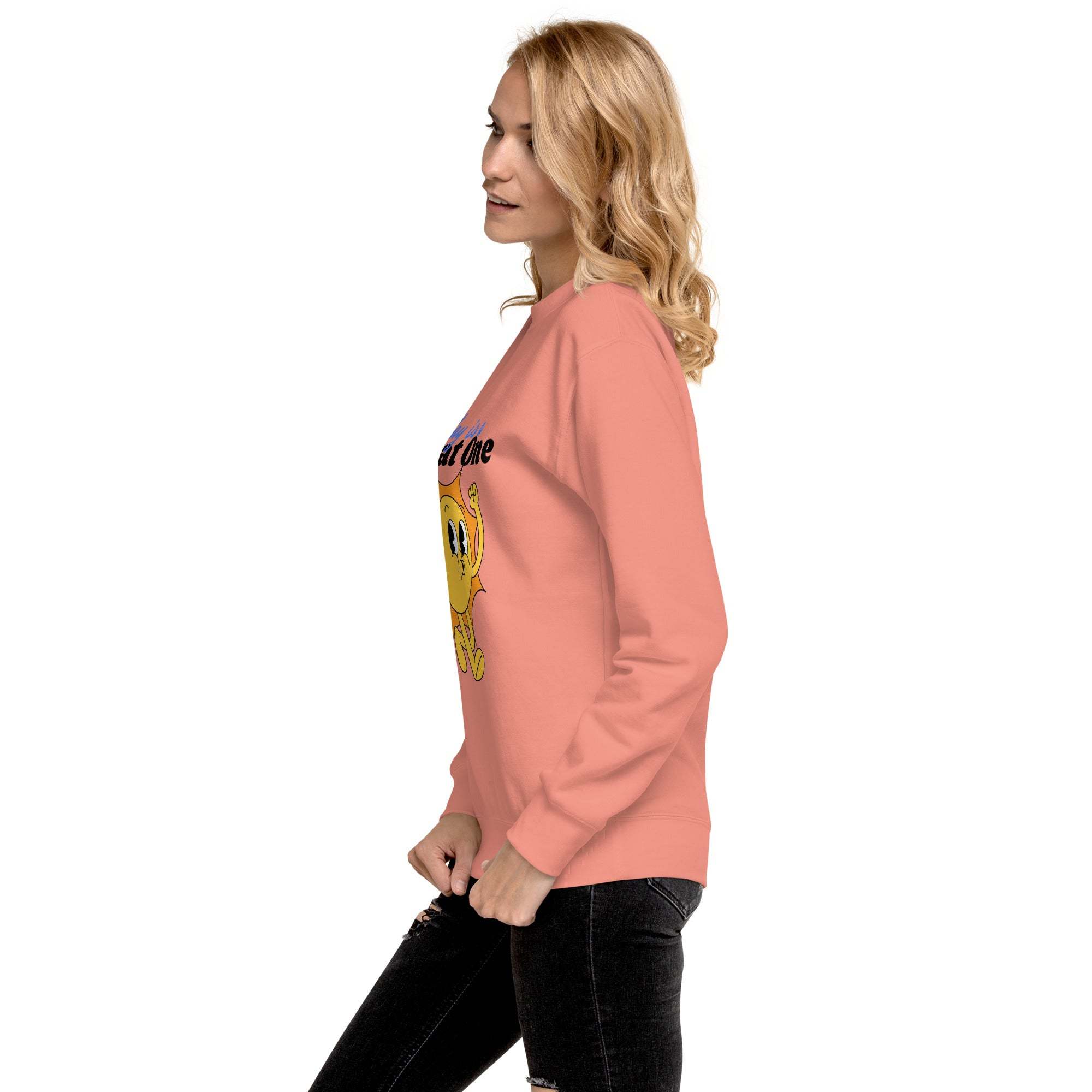 Woman wearing a pink Positive Sun Sweatshirt with motivational sun graphic, side view