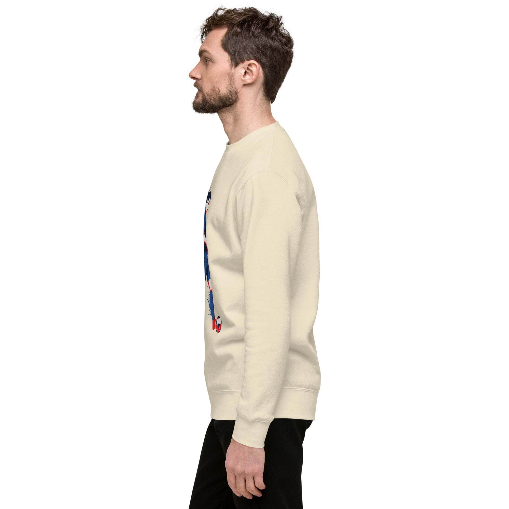 Side view of man wearing beige soccer player sweatshirt with sports graphic and black pants