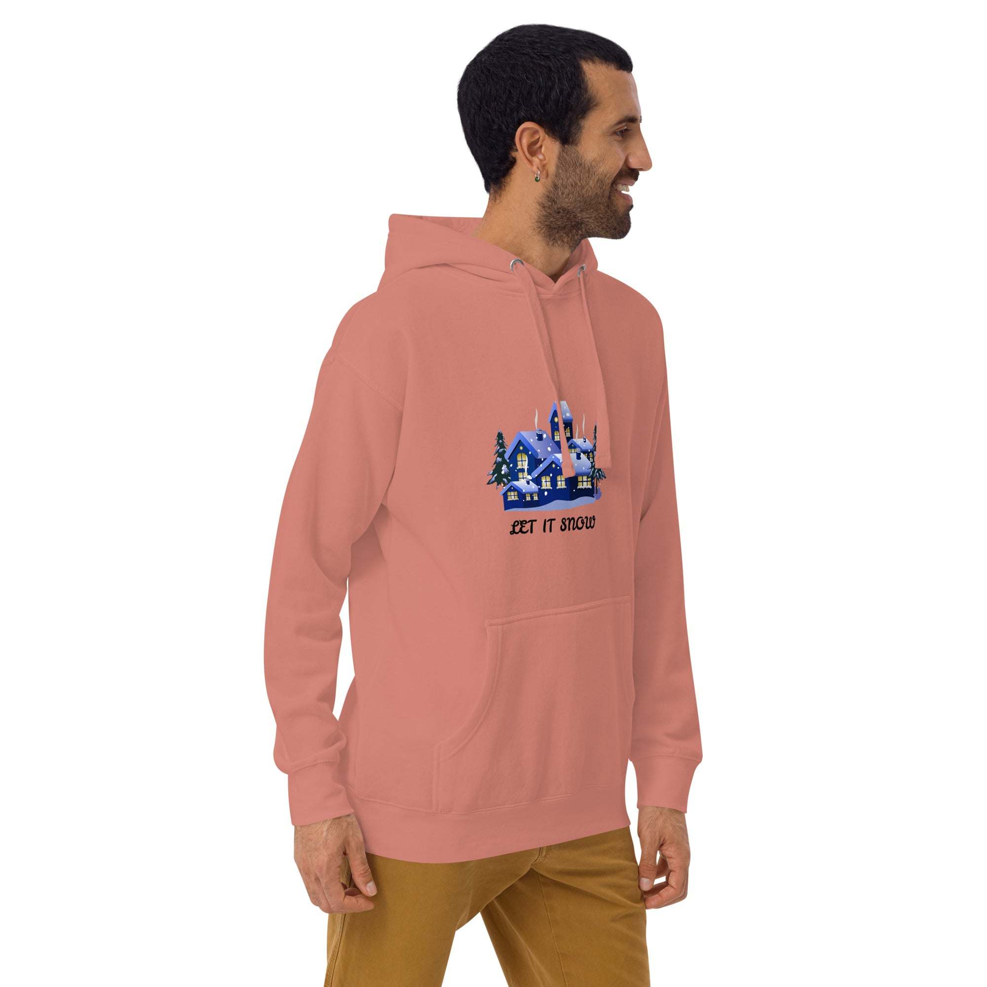 Man wearing a pink Let It Snow Hoodie with snowy village print, front pocket, and adjustable hood