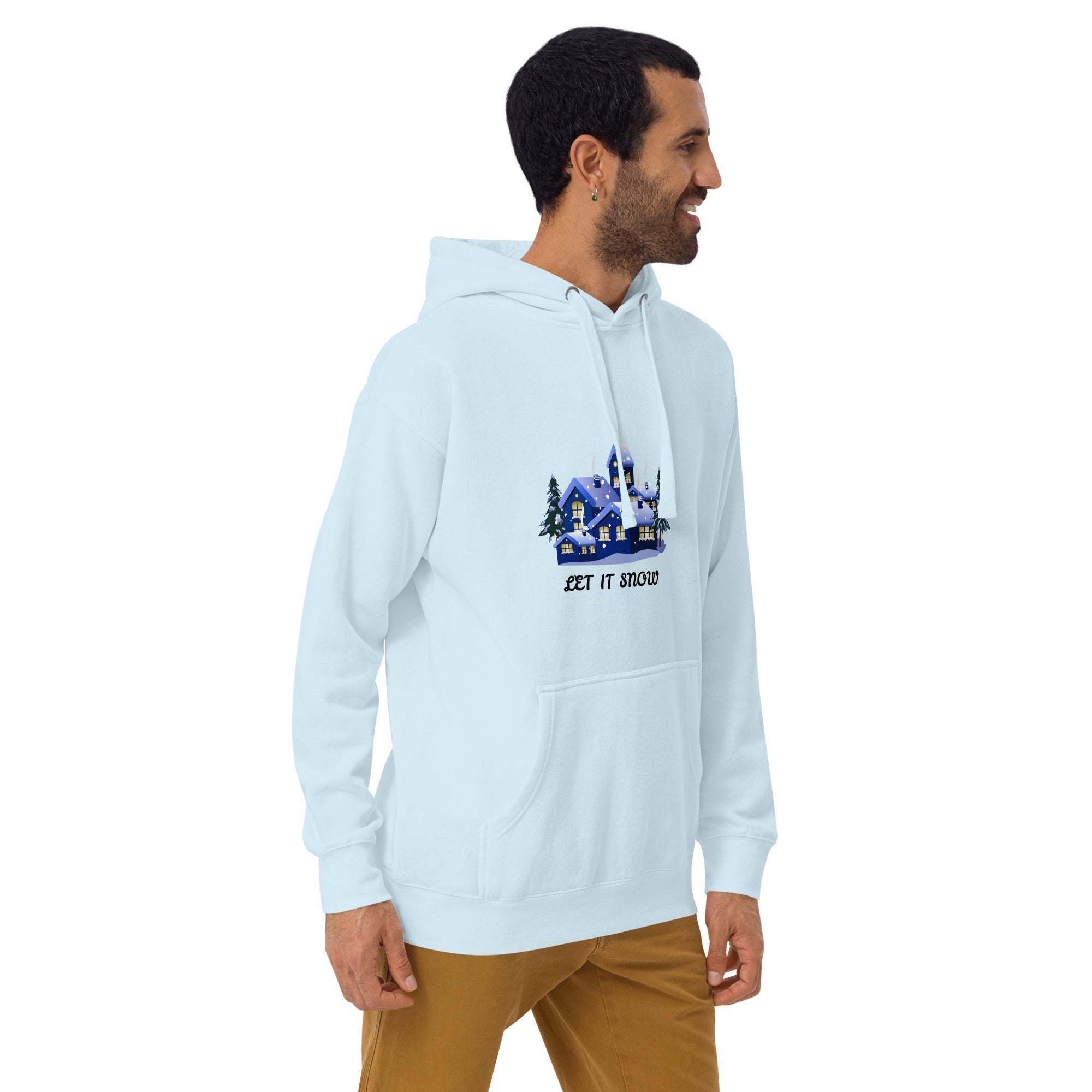Man wearing a light blue Let It Snow Hoodie with snowy village design and front pocket, styled for winter and holiday wear