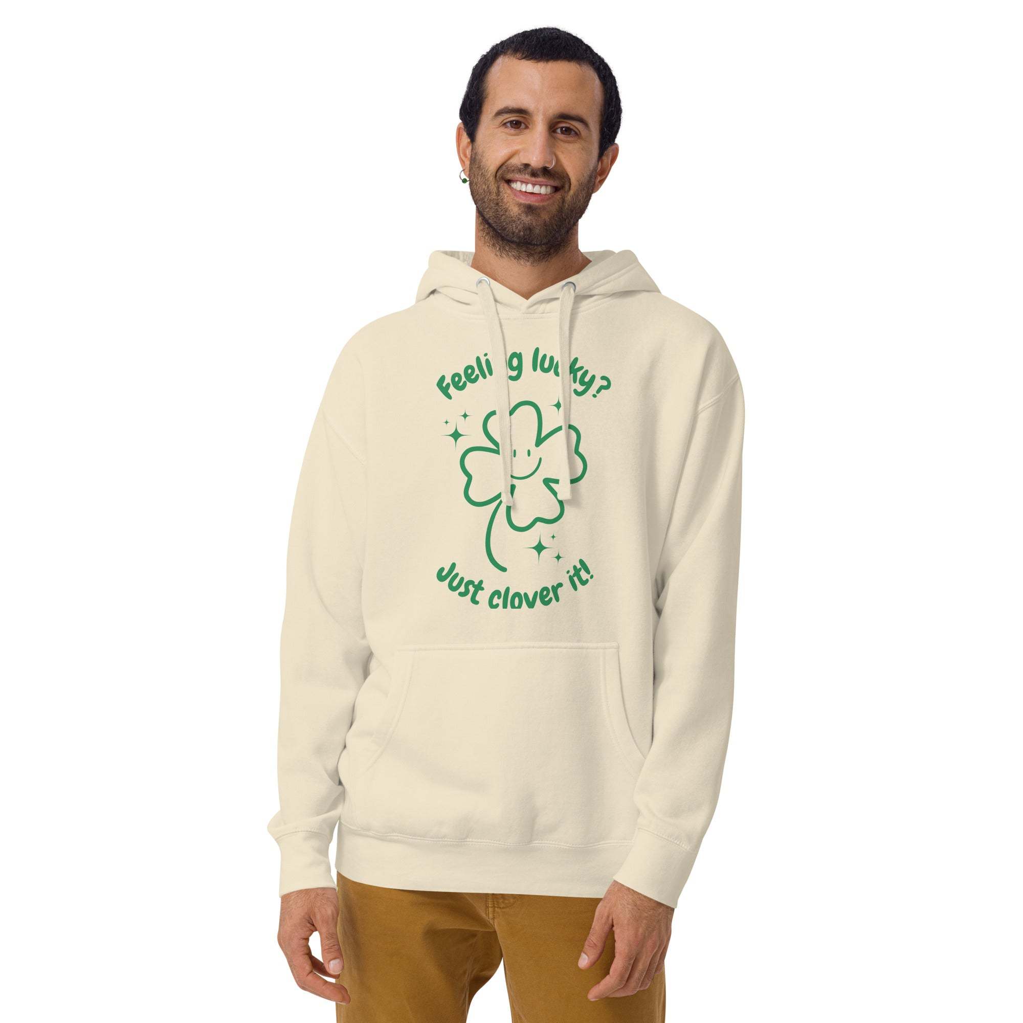 Man wearing beige Lucky Clover Hoodie with green shamrock design and "Feeling lucky? Just clover it!" text