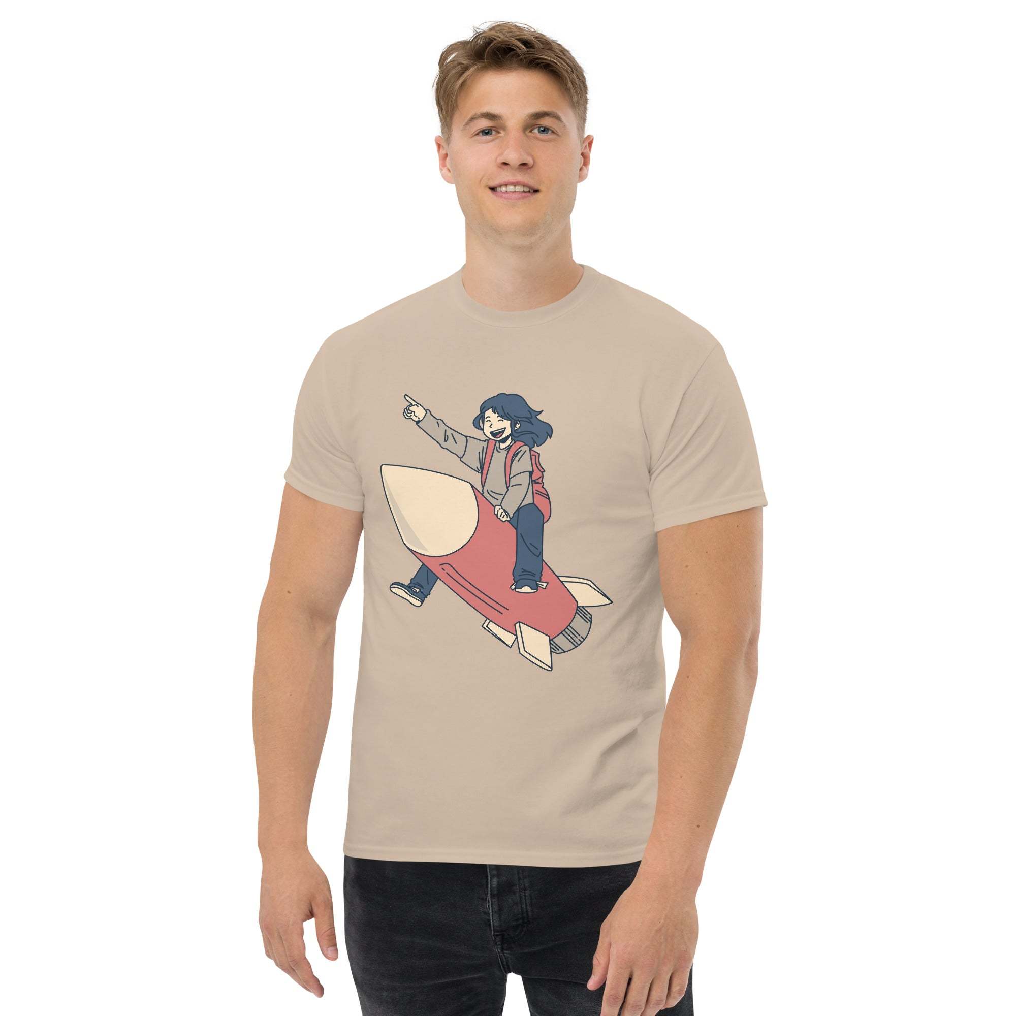 Man wearing beige Rocket Ride T-Shirt with retro cartoon astronaut riding a red rocket graphic.