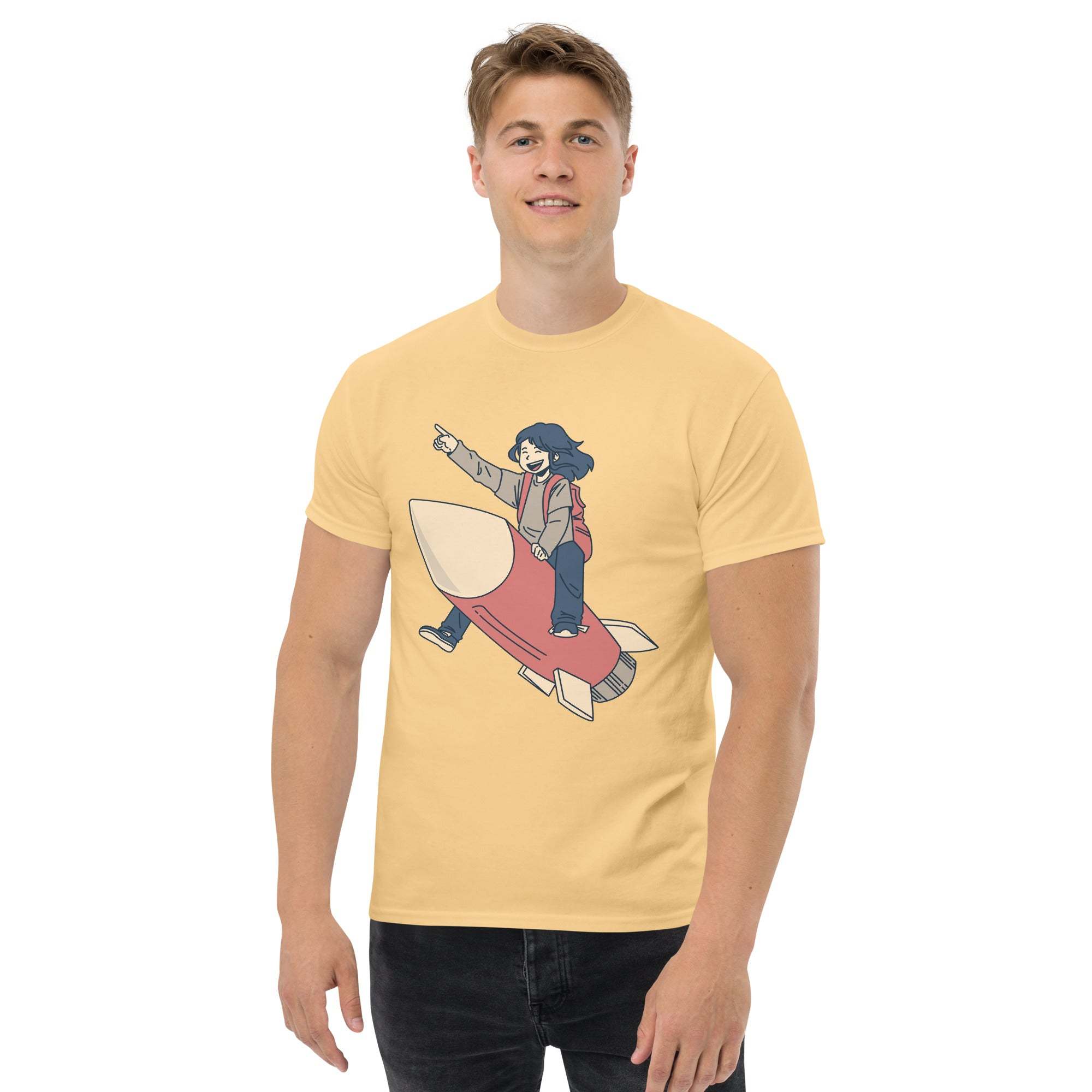 Young man wearing a yellow Rocket Ride T-Shirt with retro cartoon astronaut riding a rocket graphic