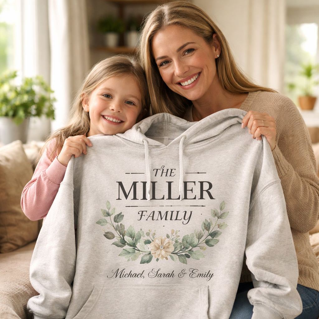 Mother and child holding a custom family name hoodie in warm home setting with realistic fabric texture