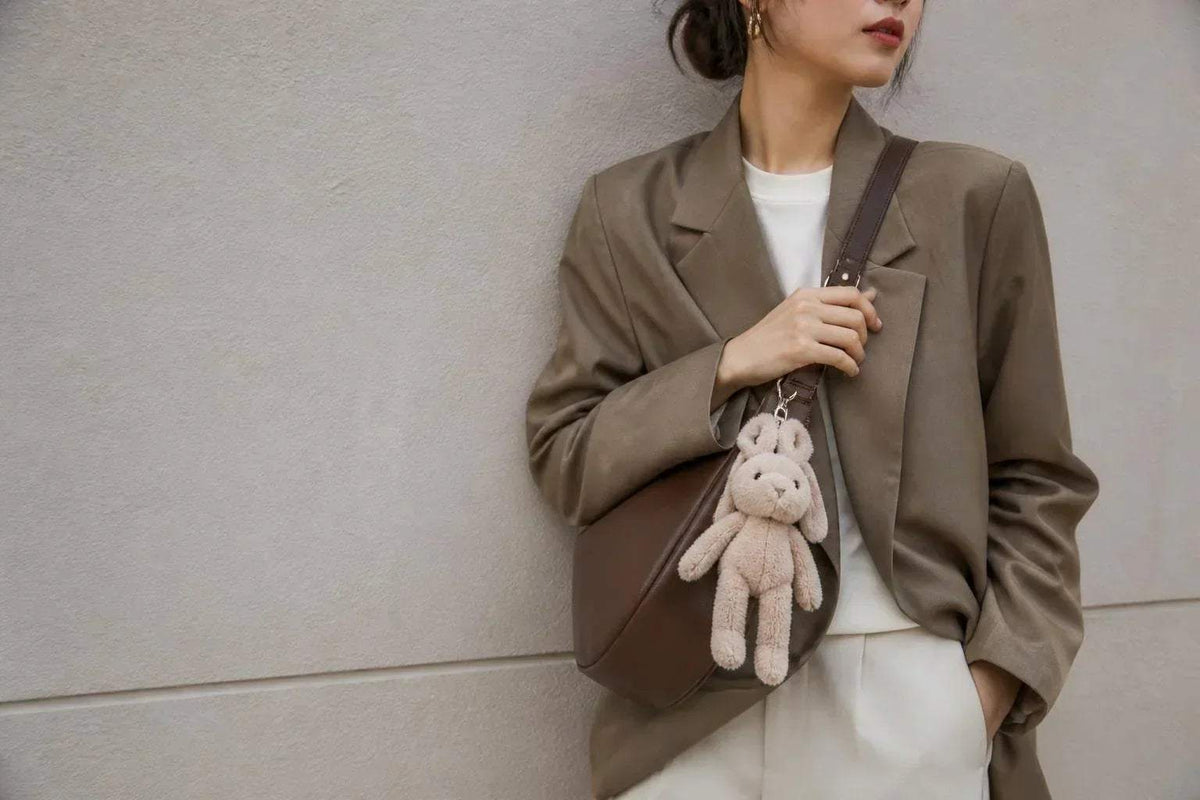 Plush Accessories include a small beige plush rabbit bag charm with long ears, dangling from a brown shoulder bag strap.