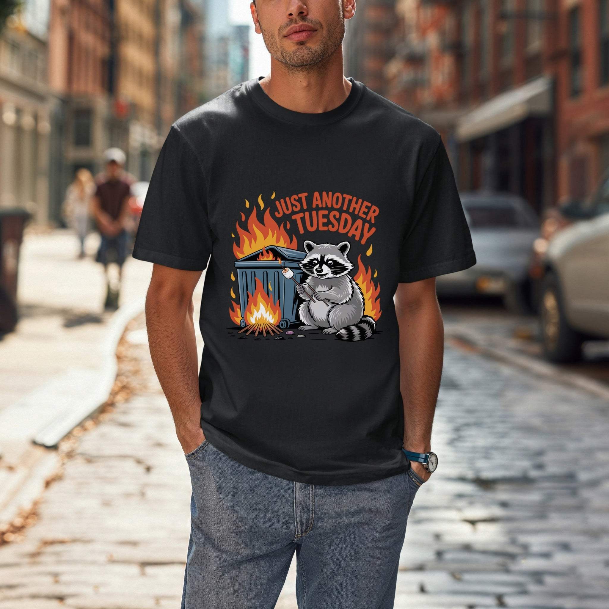 Man wearing a black t-shirt with a raccoon graphic and text on a city street.