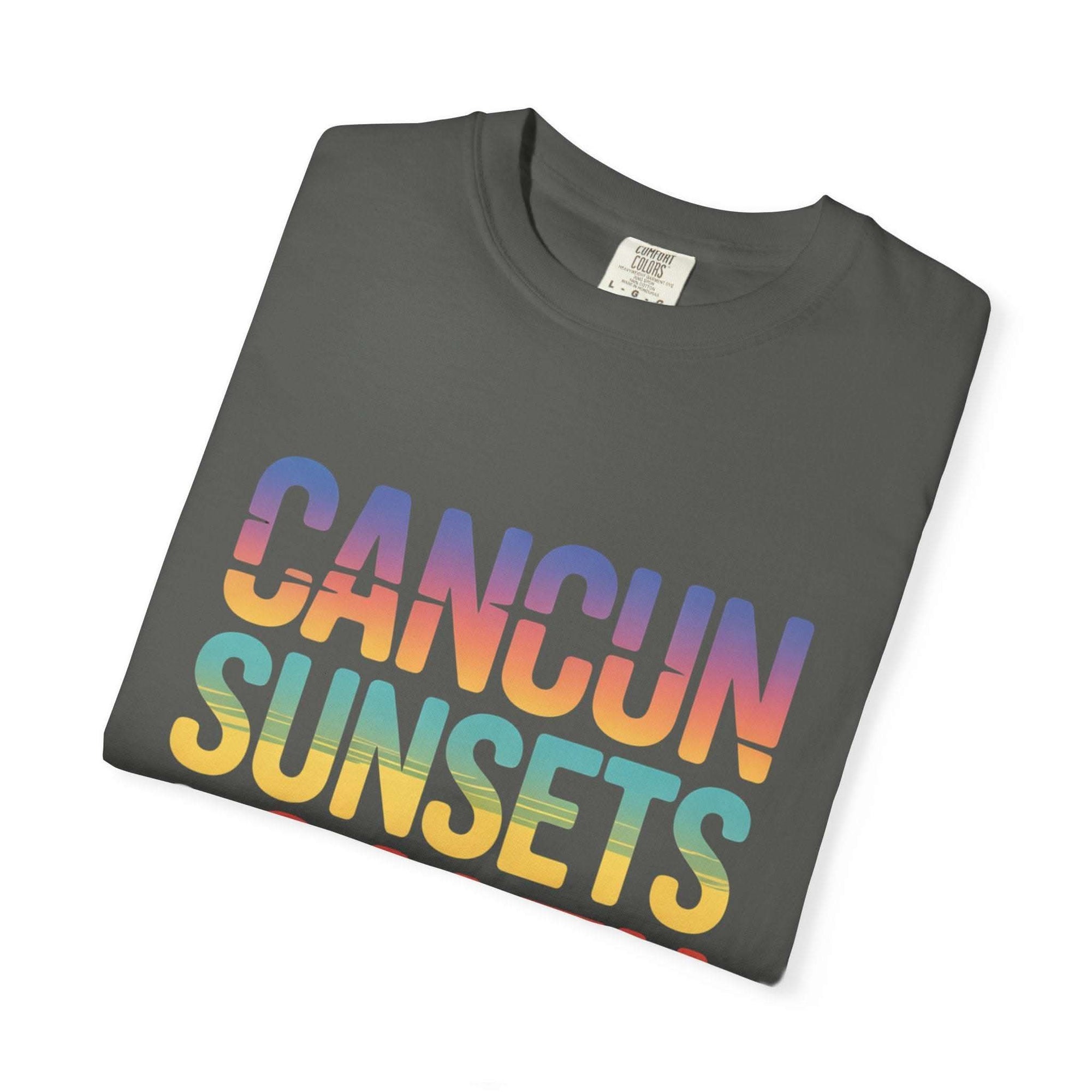 Folded t-shirt with 'Cancun Sunsets' text in rainbow colors on a white background