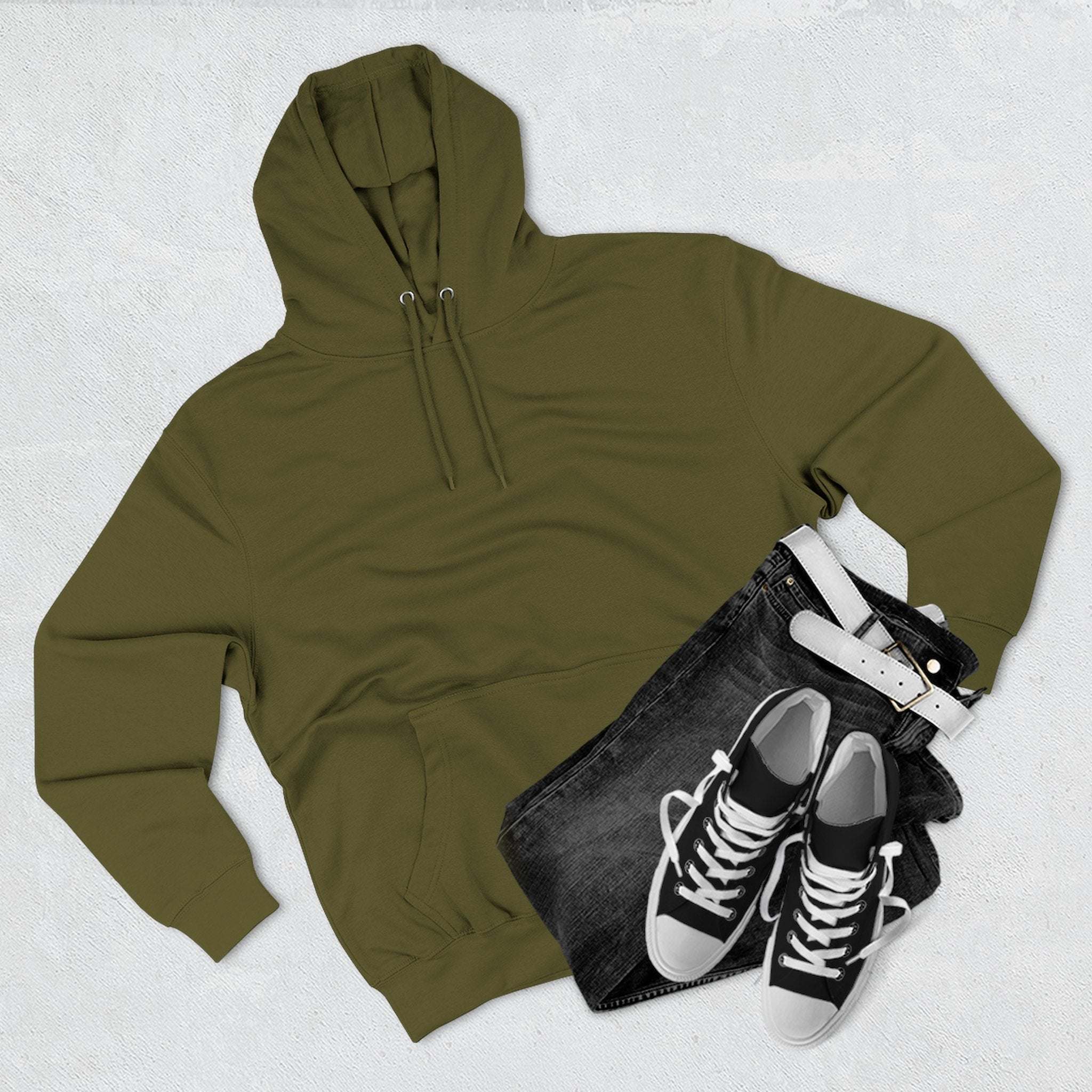 olive green fleece hoodie with kangaroo pocket, black jeans, and black sneakers flat lay on light surface