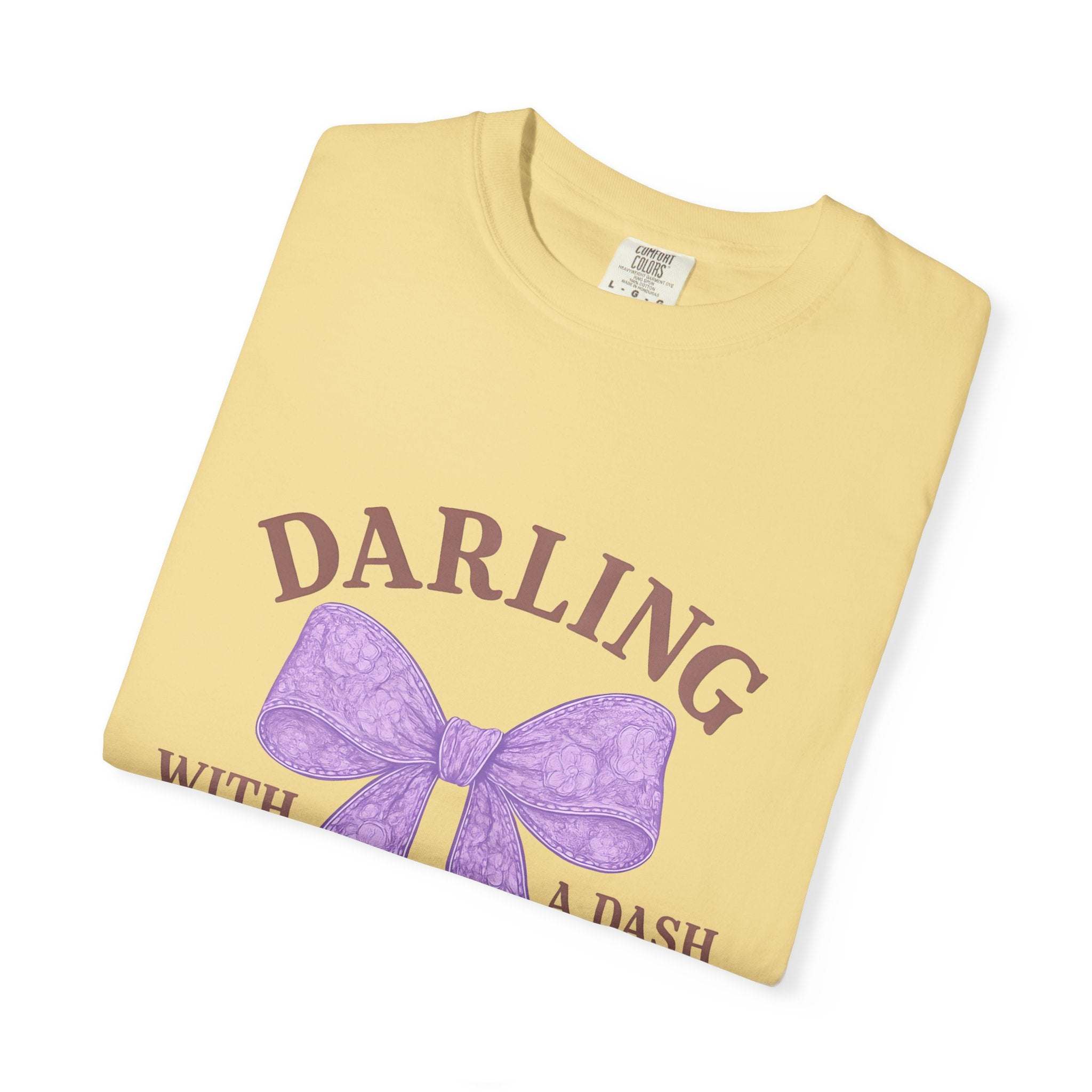 Folded yellow t-shirt with a purple bow and text on a white background