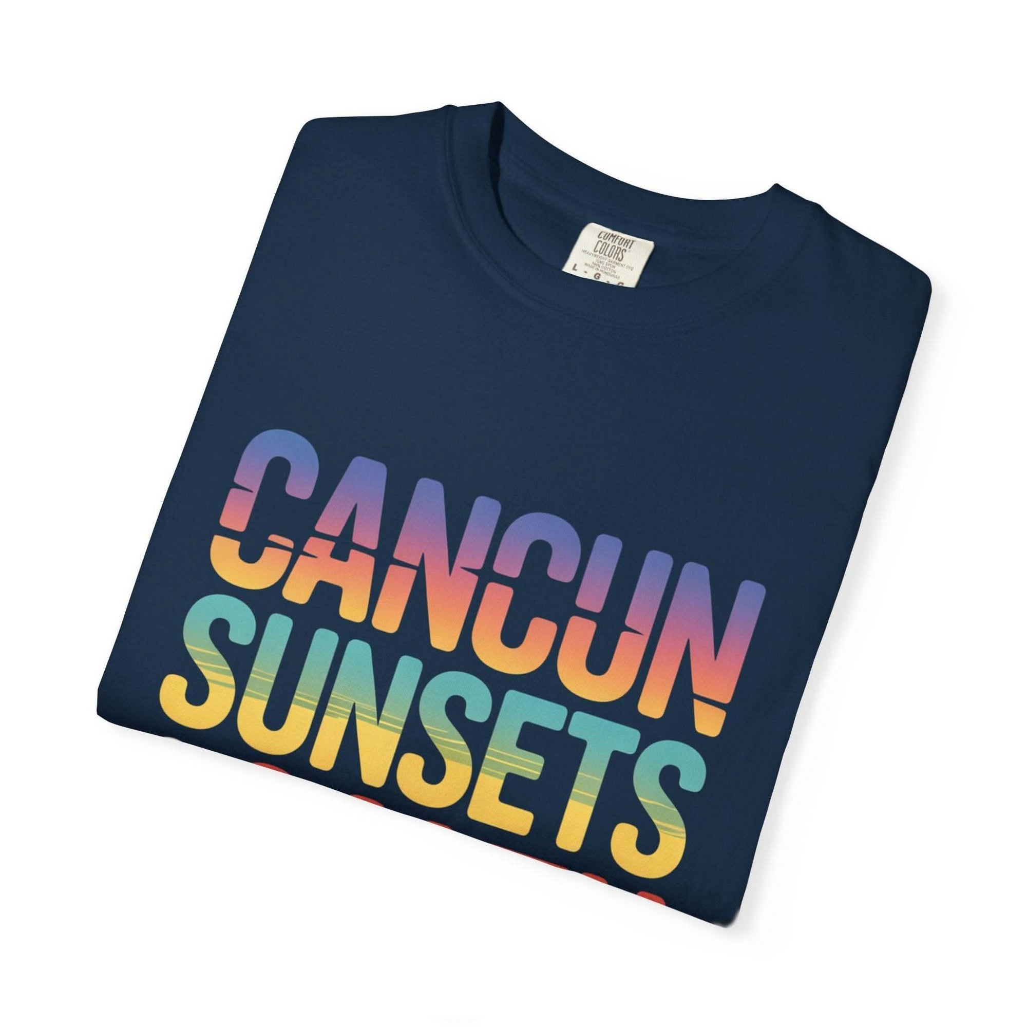 Folded navy blue t-shirt with 'Cancun Sunsets' text in gradient colors on a white background