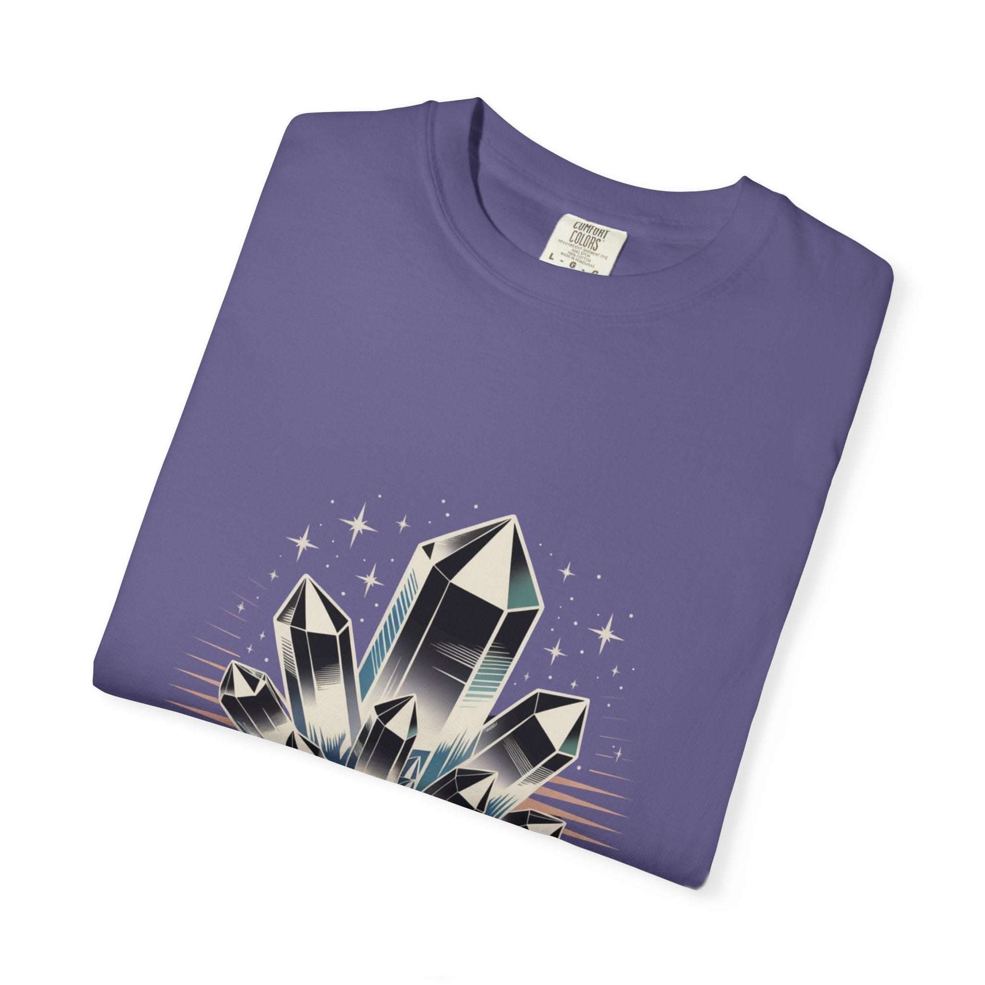 Folded purple t-shirt with crystal graphic on a white background