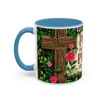 Mug with floral design and wooden cross on a white background
