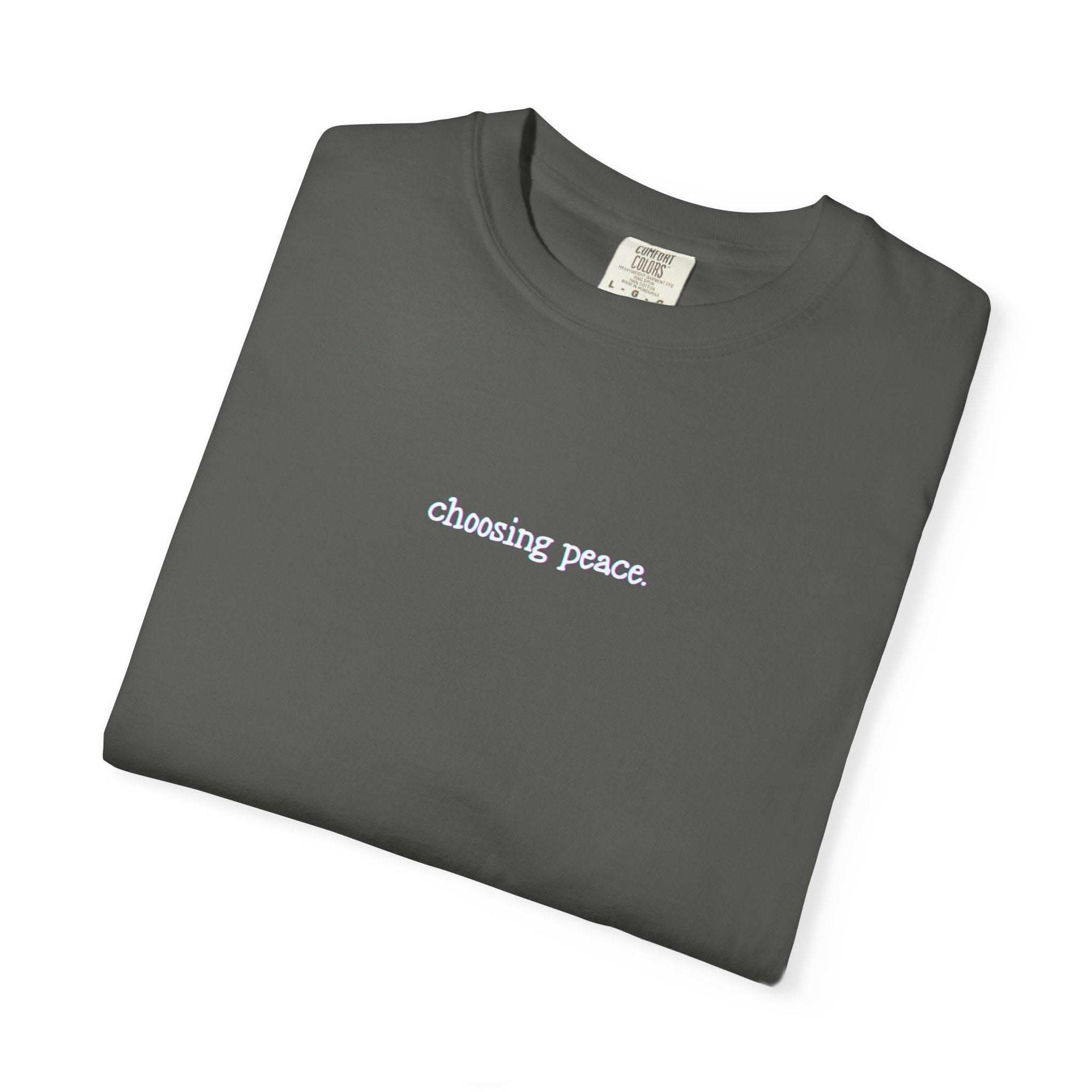 Folded dark gray t-shirt with 'choosing peace' text on a white background