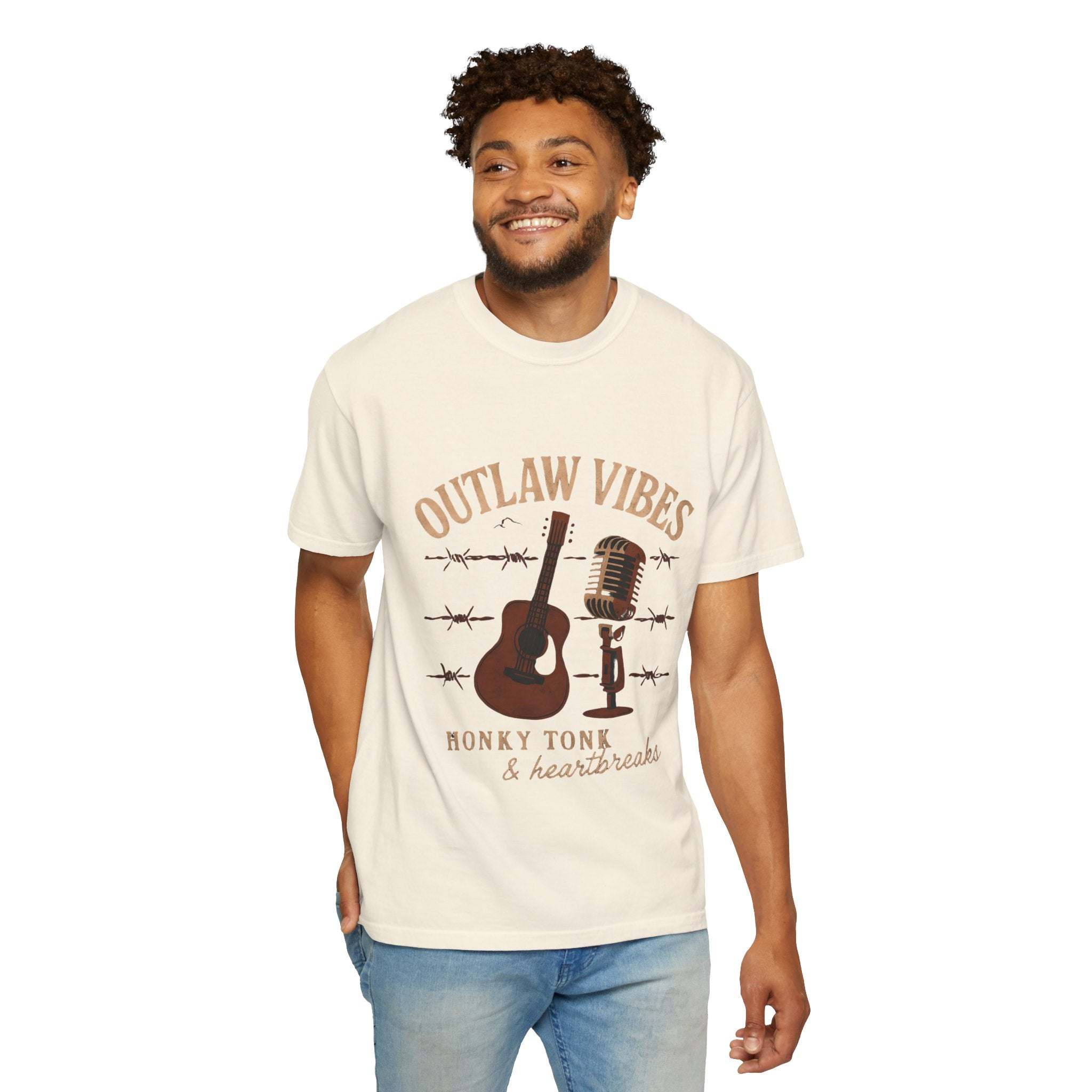 Man wearing a 'Outlaw Vibes' t-shirt with musical graphics on a white background