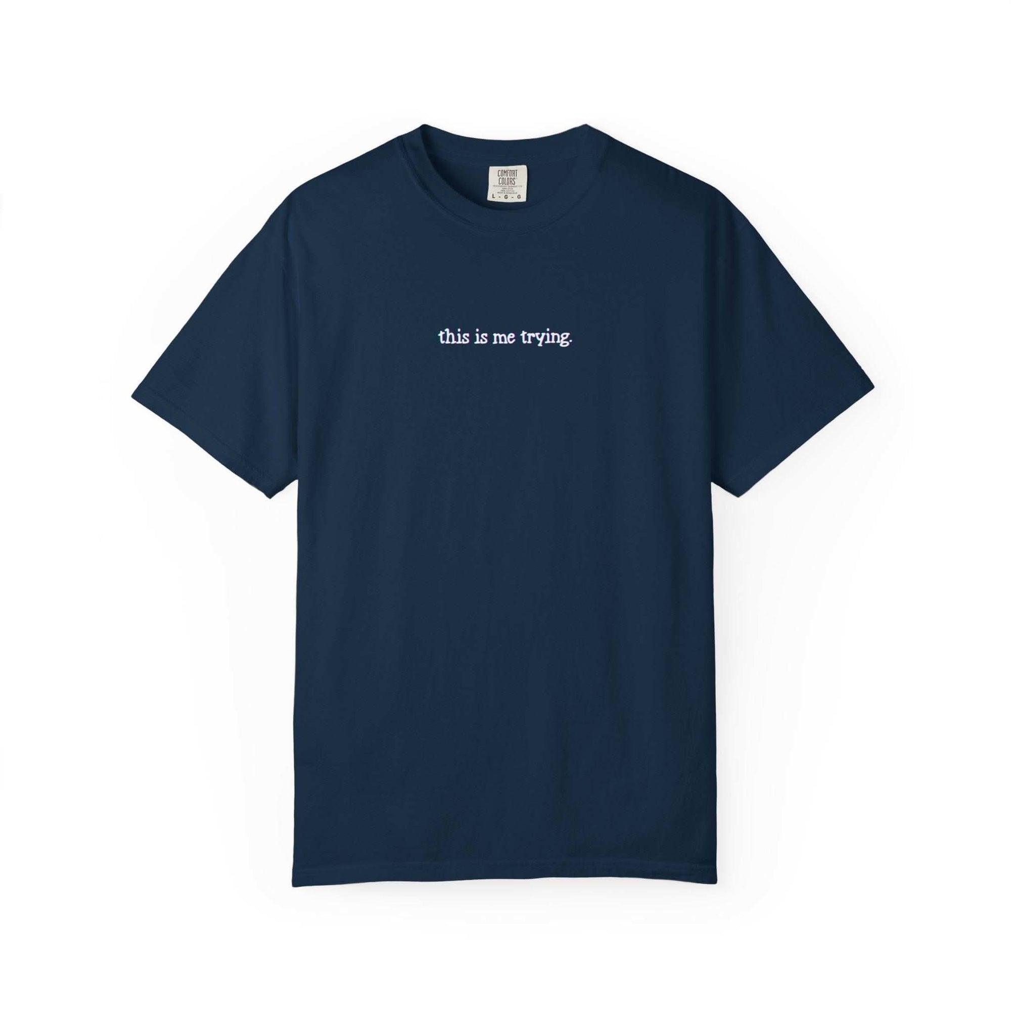 Navy blue t-shirt with 'this is me trying' text on a white background