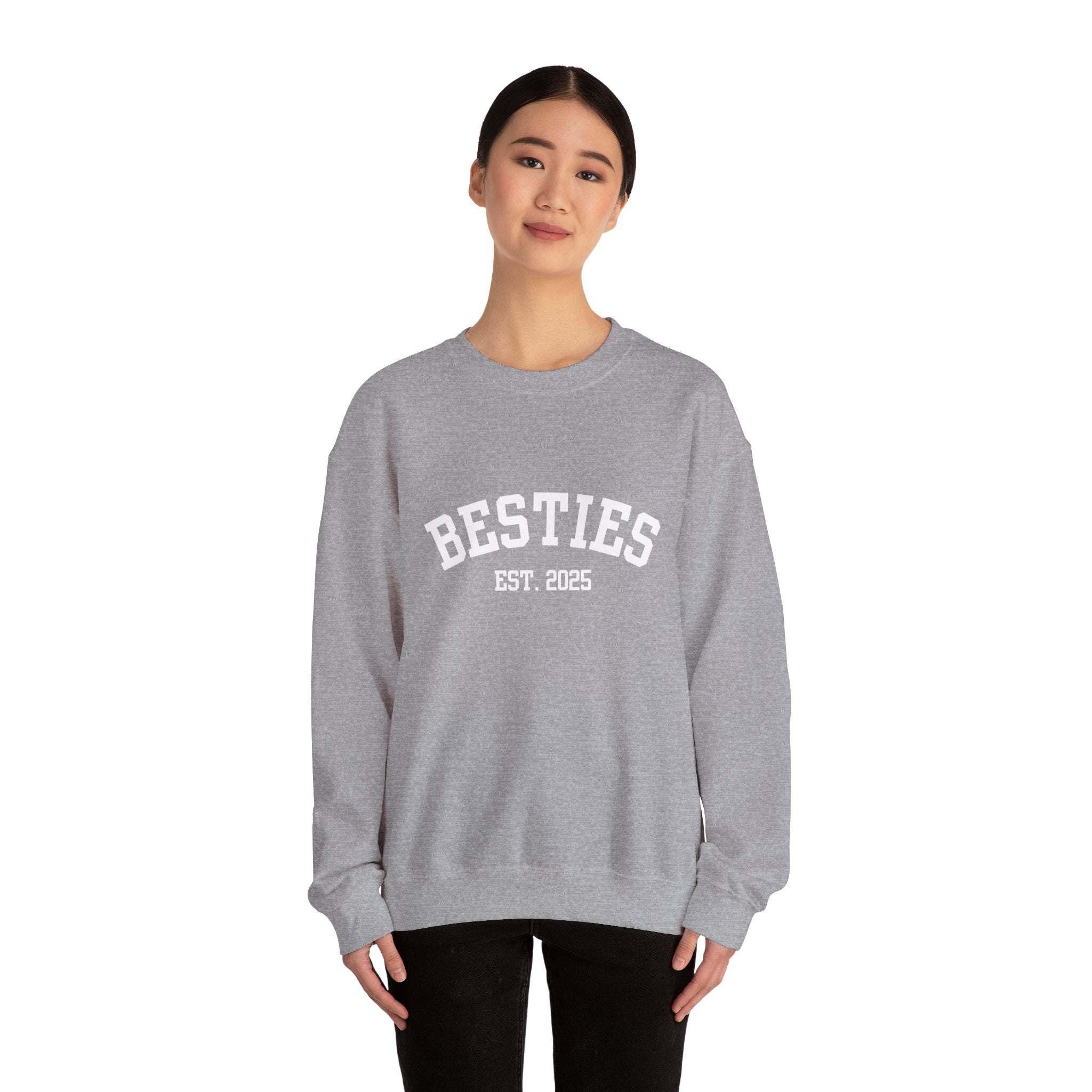 Person wearing a gray sweatshirt with 'BESTIES EST. 2025' text on a white background