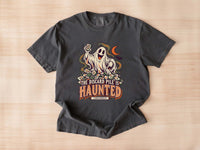 Flat lay of a pepper Comfort Colors 1717 Halloween mahjong T-shirt with a ghost holding a tile and “The Discard Pile Is Haunted (Obviously)” lettering.