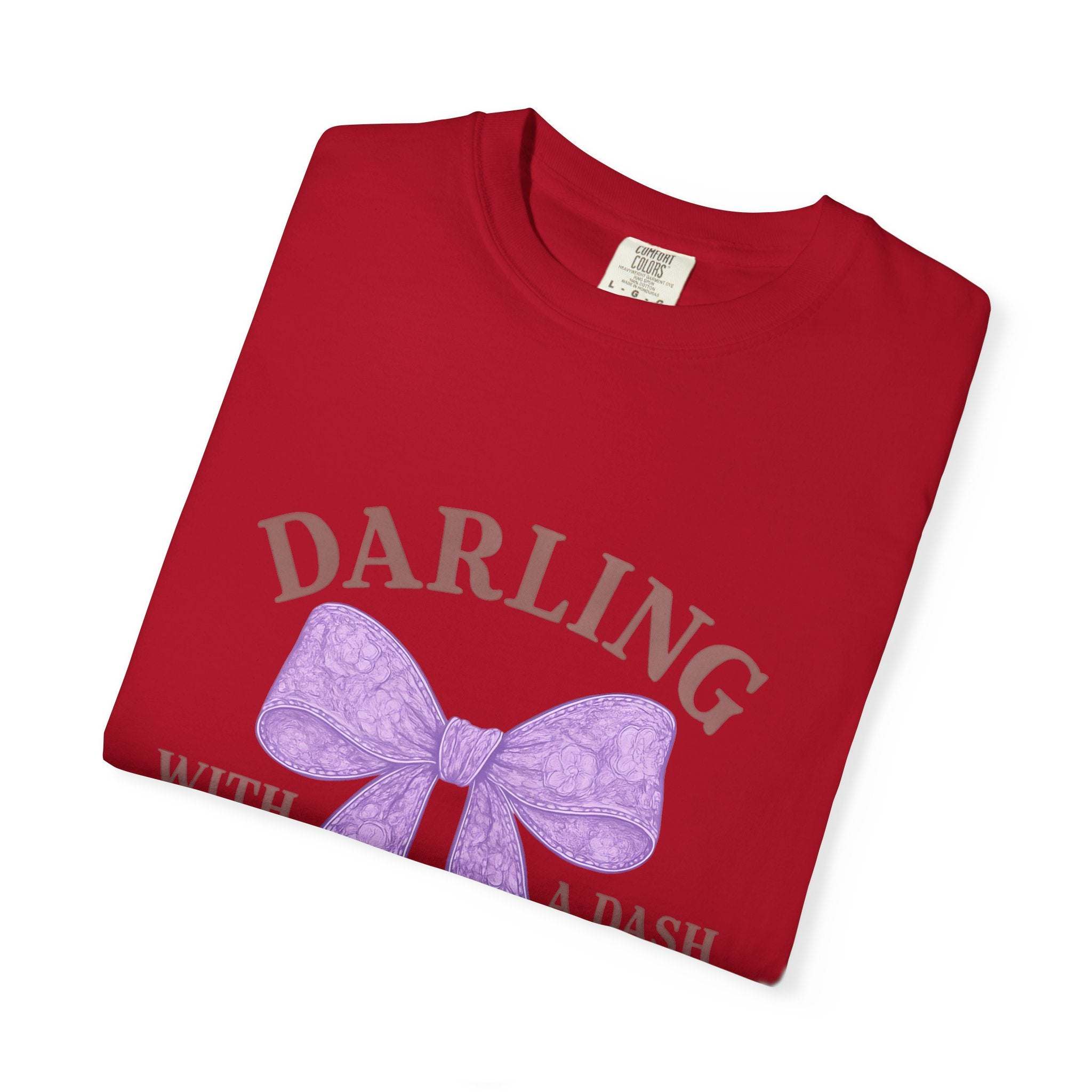 Folded red t-shirt with a purple bow and text on a white background