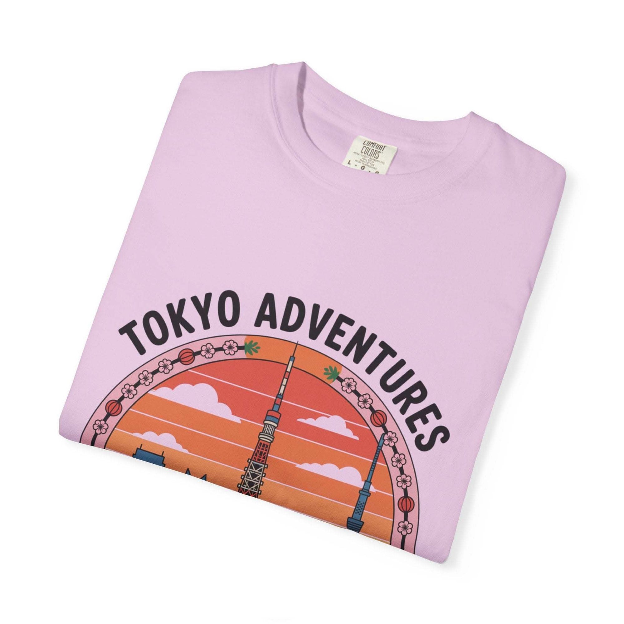 Folded garment-dyed T-shirt in light purple with Tokyo Adventures travel graphic and Japanese cultural design
