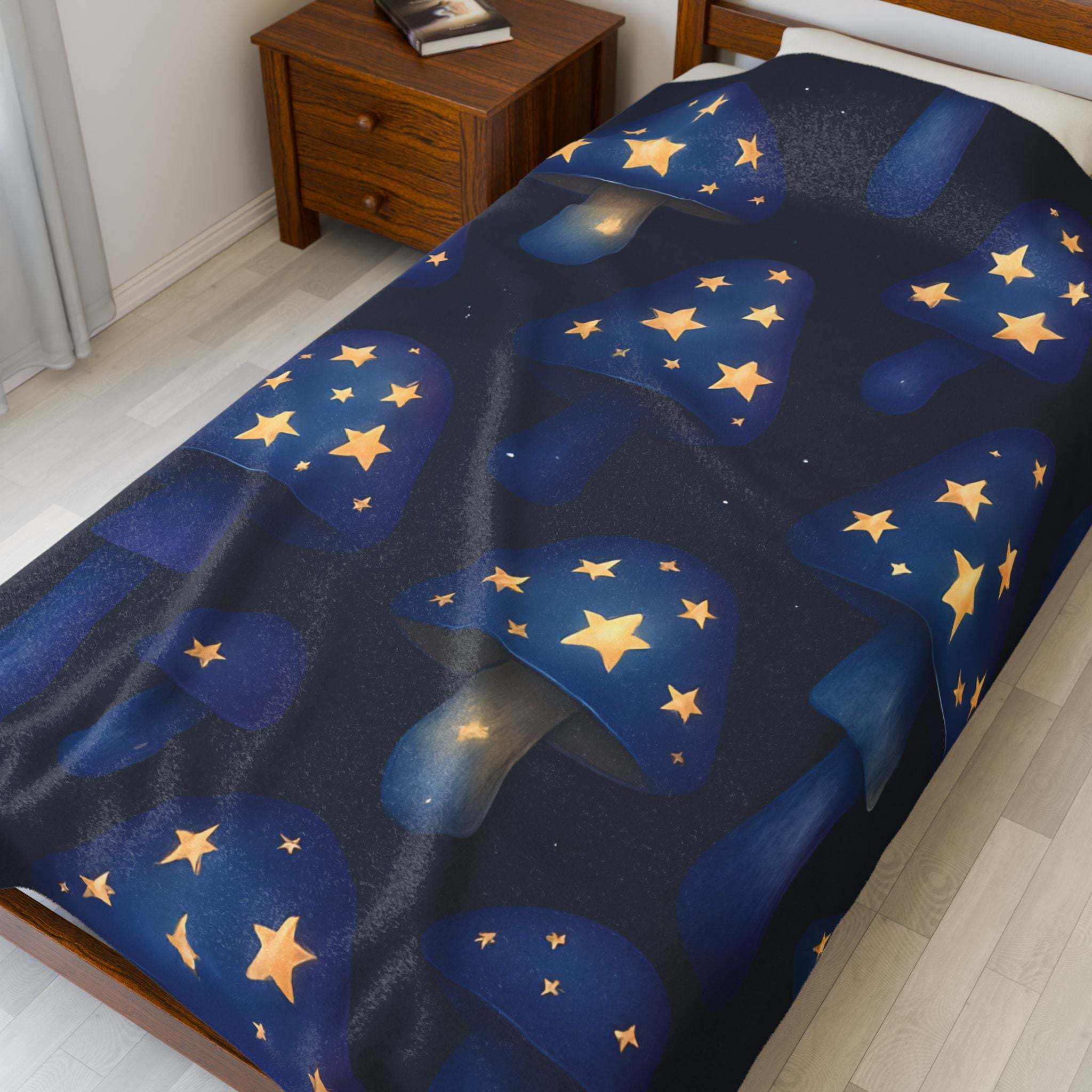Plush blanket with whimsical blue mushrooms and glowing stars on bed in cozy bedroom setting