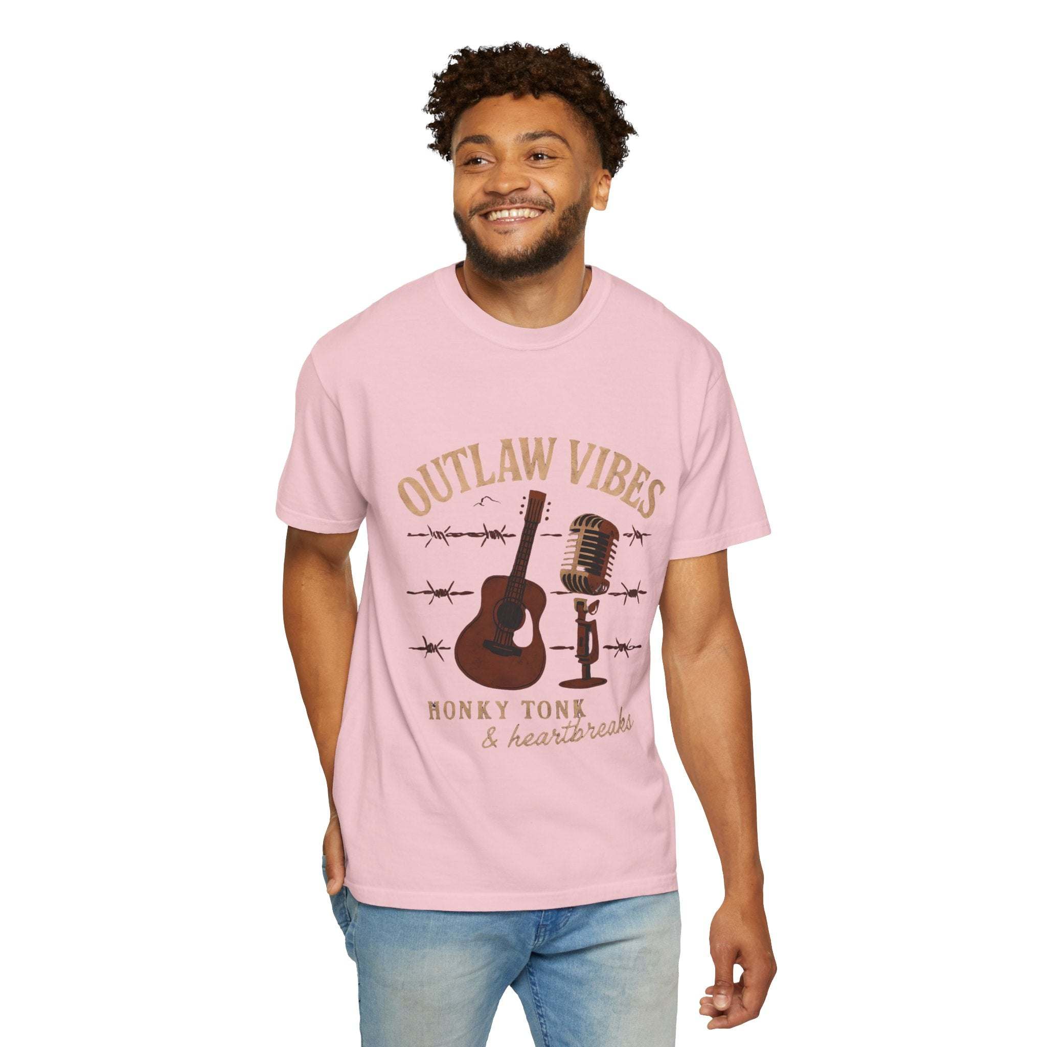 Man wearing a pink t-shirt with 'Outlaw Vibes' graphic design on a white background