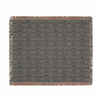 Victorian Gothmas Woven Blanket with candlelight hues and colorful fringed edges draped over dark velvet