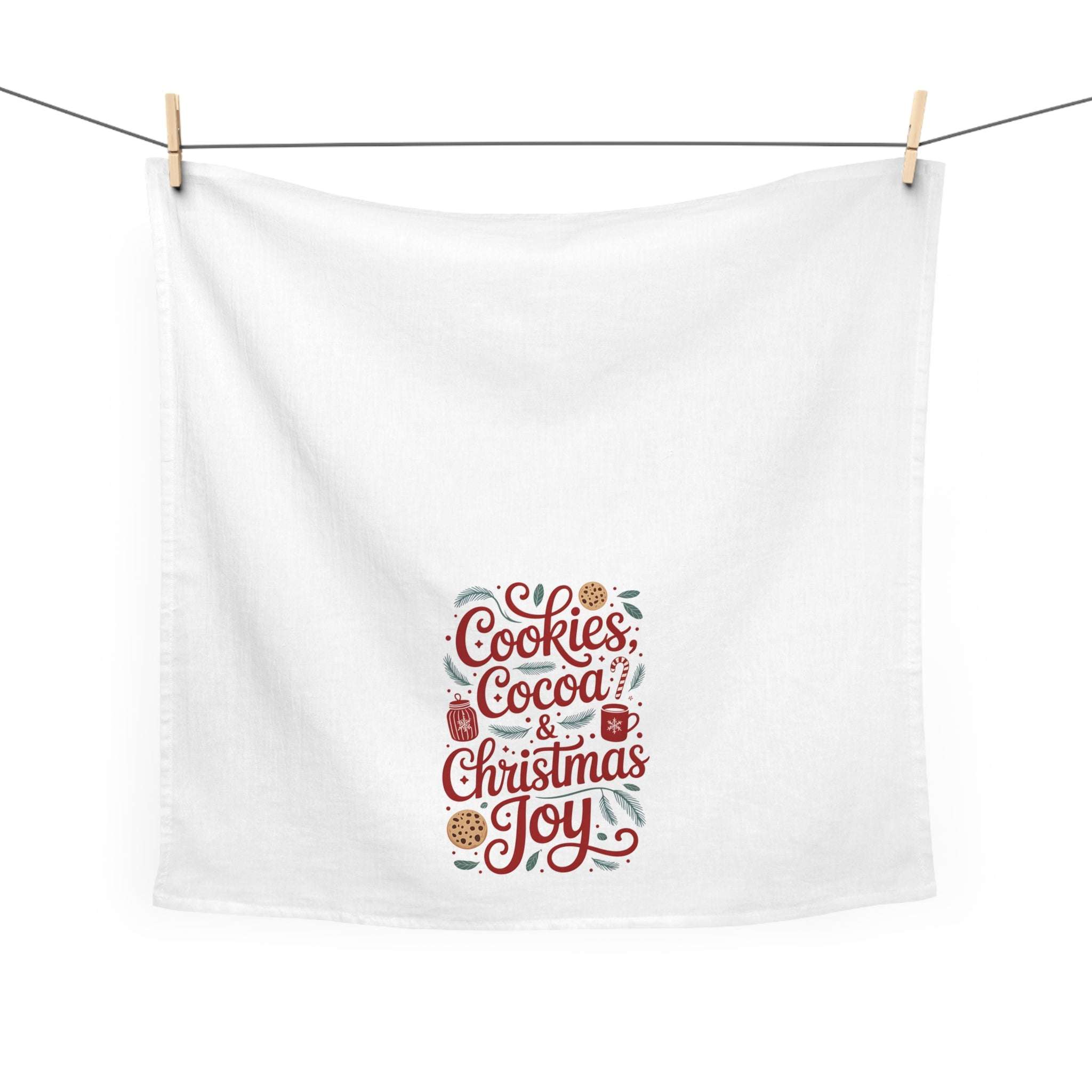 Christmas Tea Towel with festive cookies, cocoa, and Christmas joy design on white cotton fabric hanging on a line