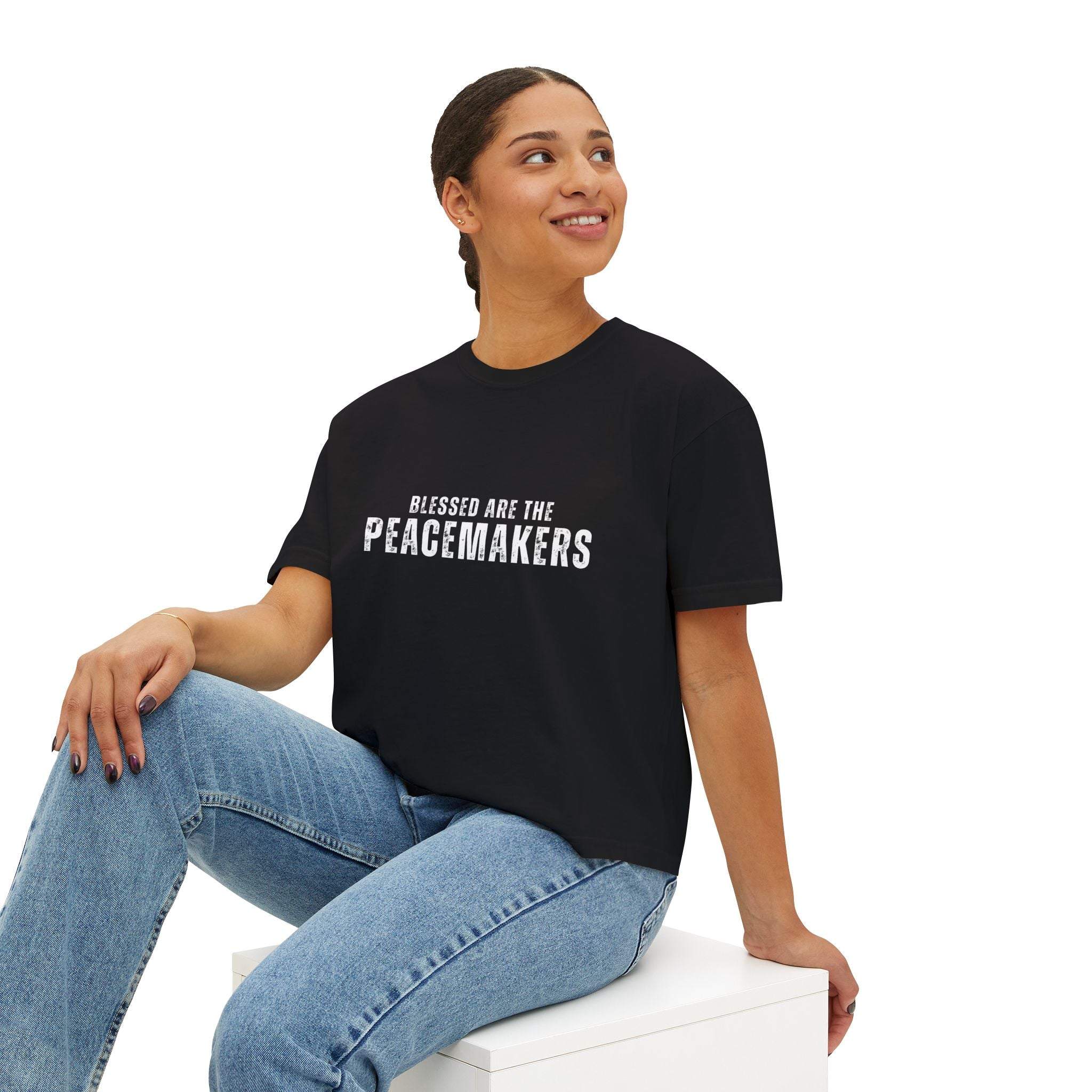 Women's black boxy tee Blessed be the Peacemakers with white text, styled with jeans