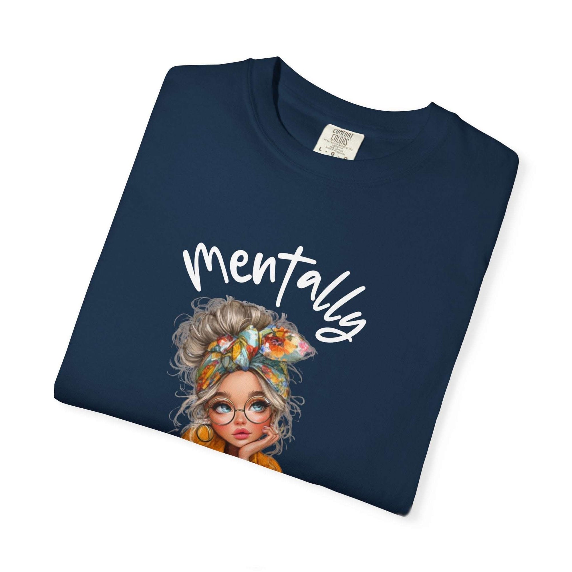 Folded navy blue Mentally in My Cozy Era t-shirt with hand-lettered text and graphic of a stylish woman with glasses and floral headband