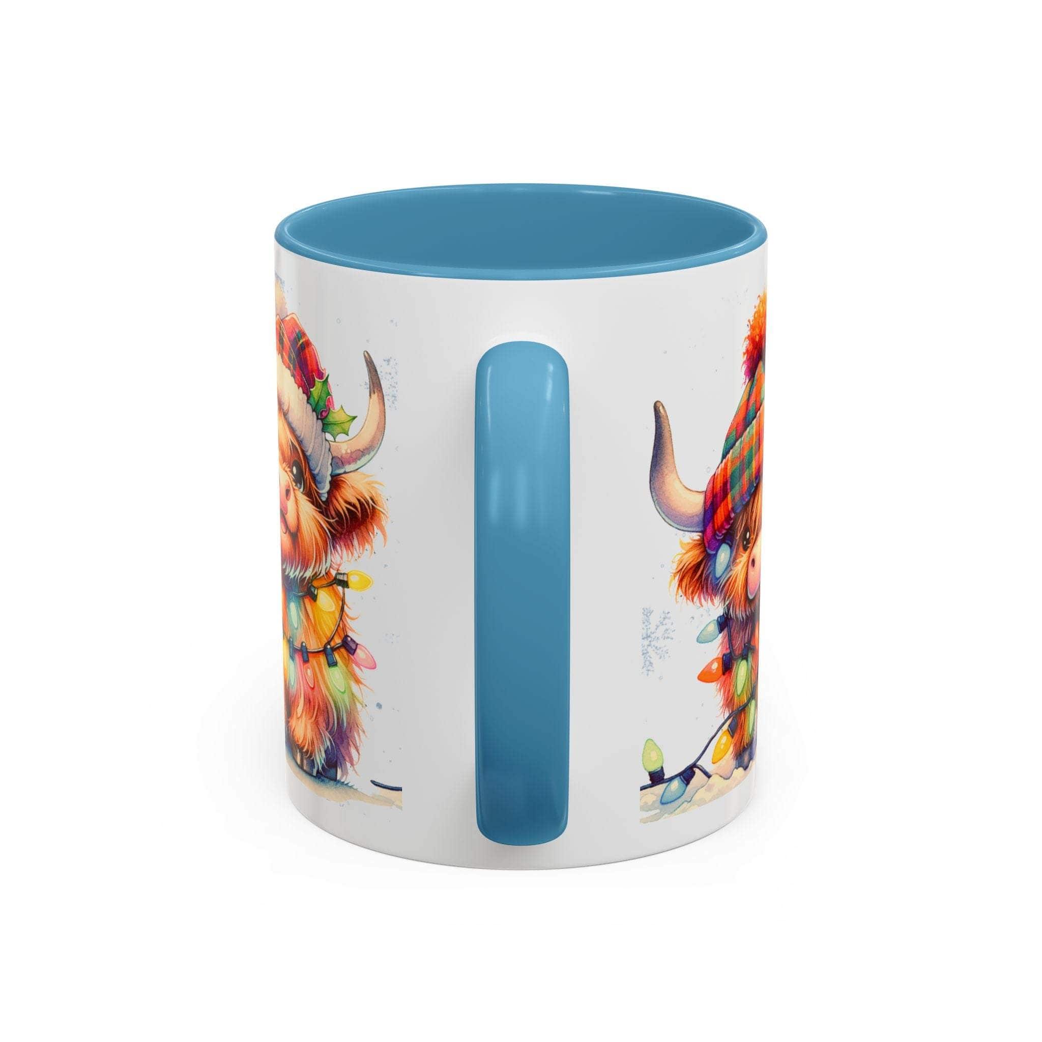 White ceramic Christmas coffee mug with blue handle and interior featuring a festive Scottish Highland Cow illustration