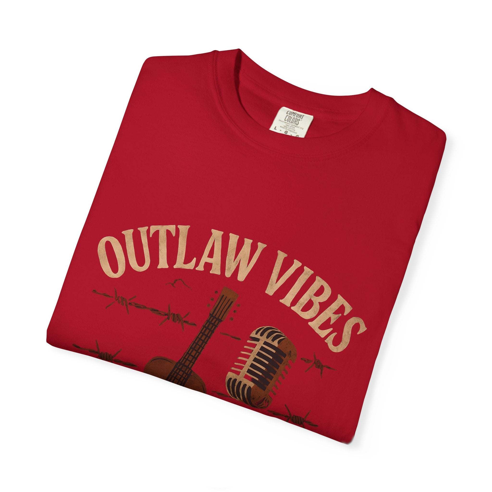 Folded red t-shirt with 'Outlaw Vibes' text and graphic on a white background