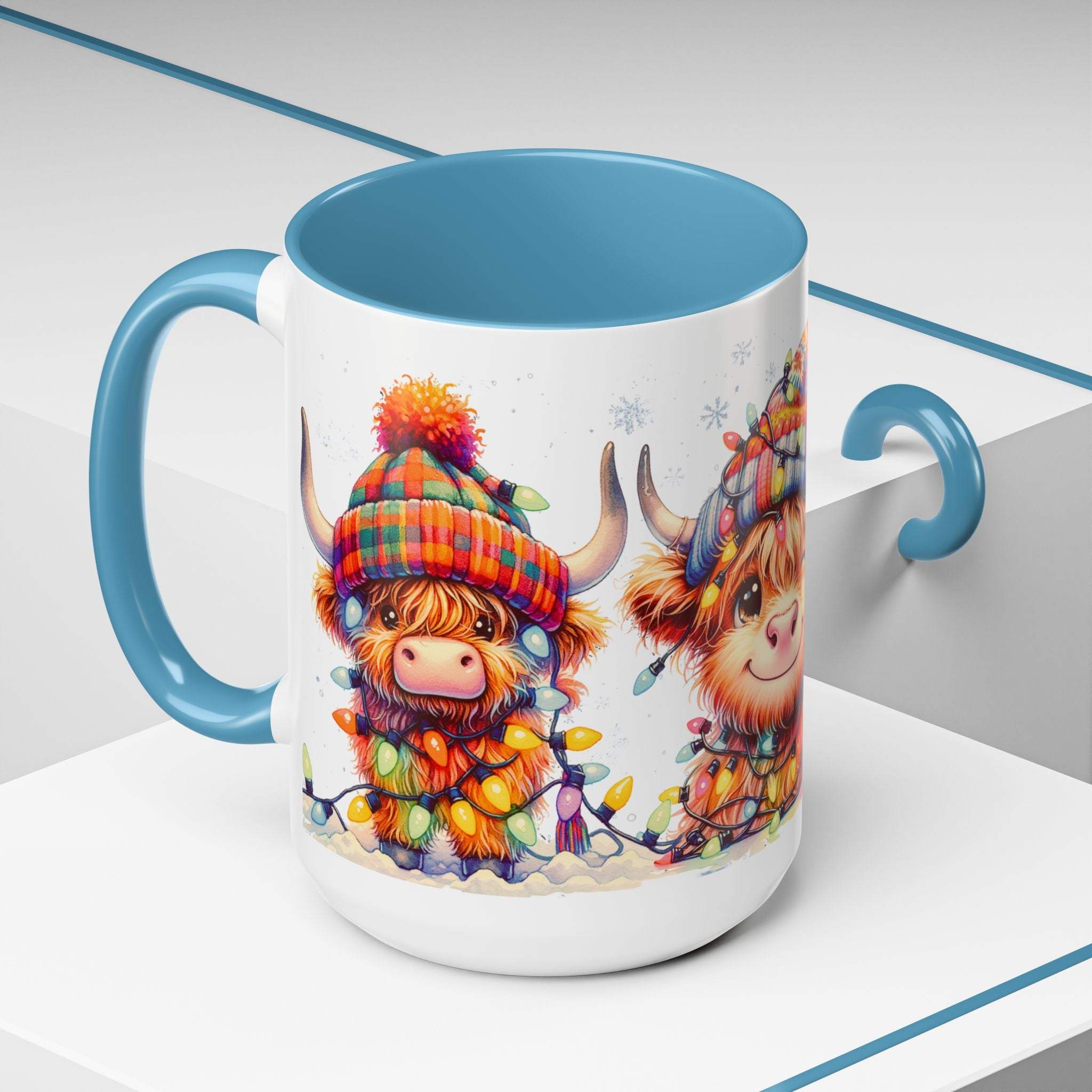 Mug with cartoon Highland cows wearing Christmas lights and a colorful hat on a white surface.