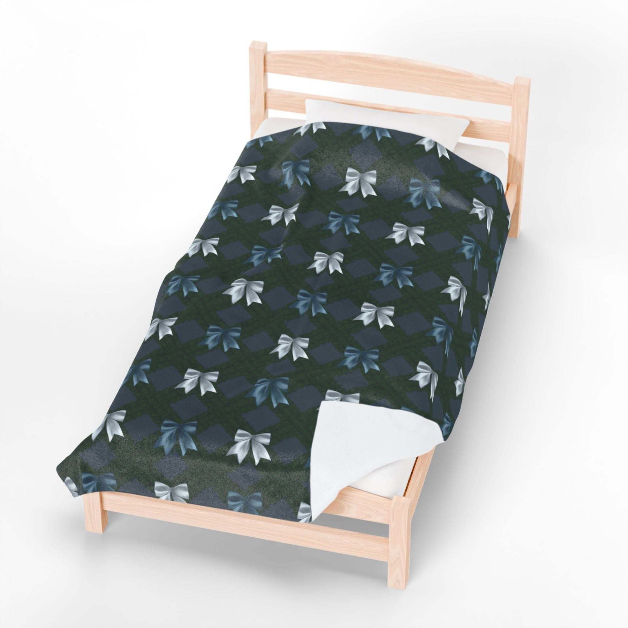 Velveteen plush blanket with winter coquette bows design on wooden bed