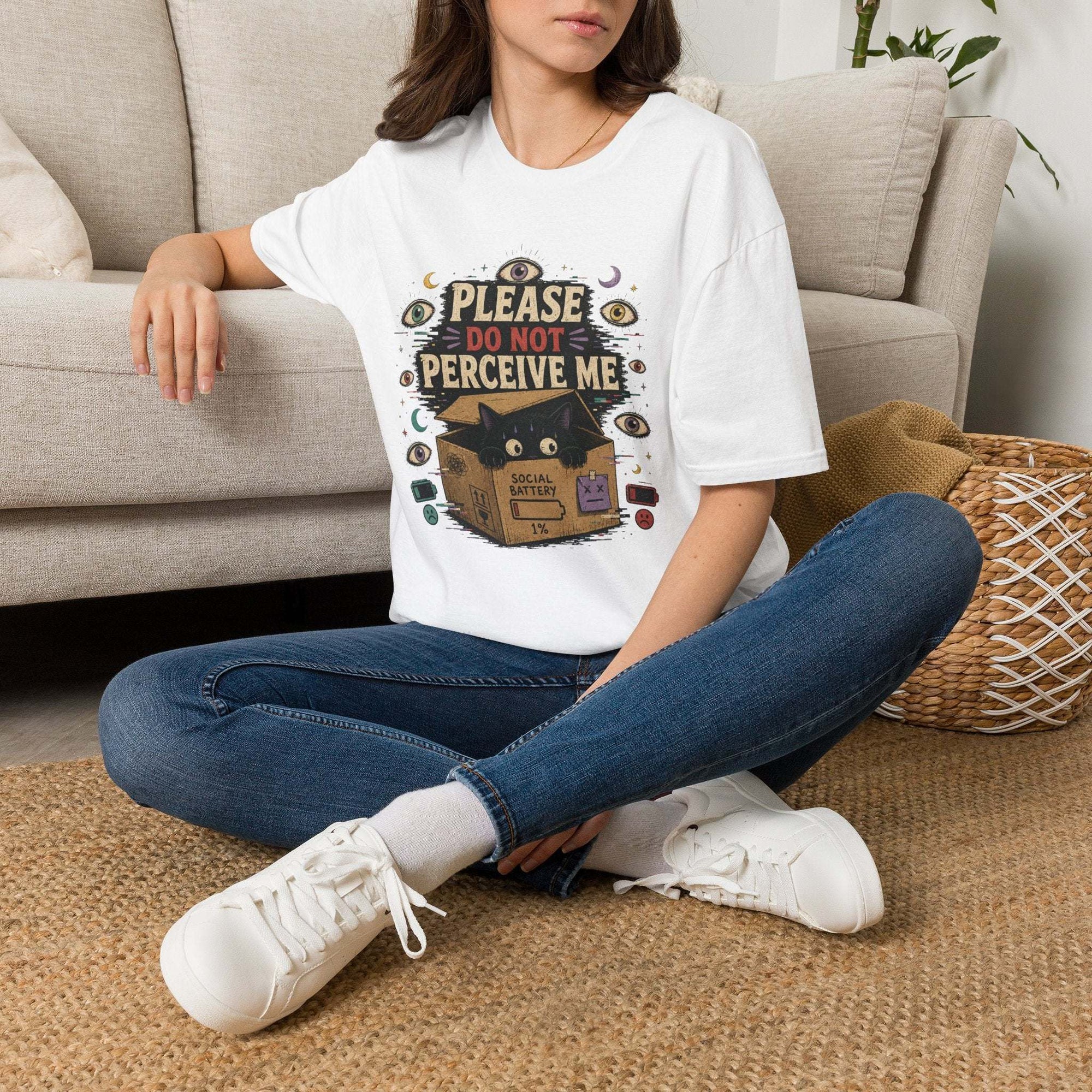 Surreal black cat inside box with "Please Do Not Perceive Me" occult graphic on t-shirt