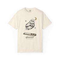 Flat lay of an ivory mahjong T-shirt with a ghost holding a joker tile above a tile rack and “ghosted (he took the joker)” lettering.