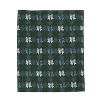 Velveteen plush blanket with winter coquette bow pattern draped on sofa for cozy comfort