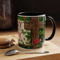 Decorative mug with floral and wooden design on a table with coffee beans and a spoon.