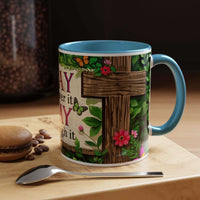 Mug with floral and butterfly design on a wooden surface with coffee beans and a spoon.