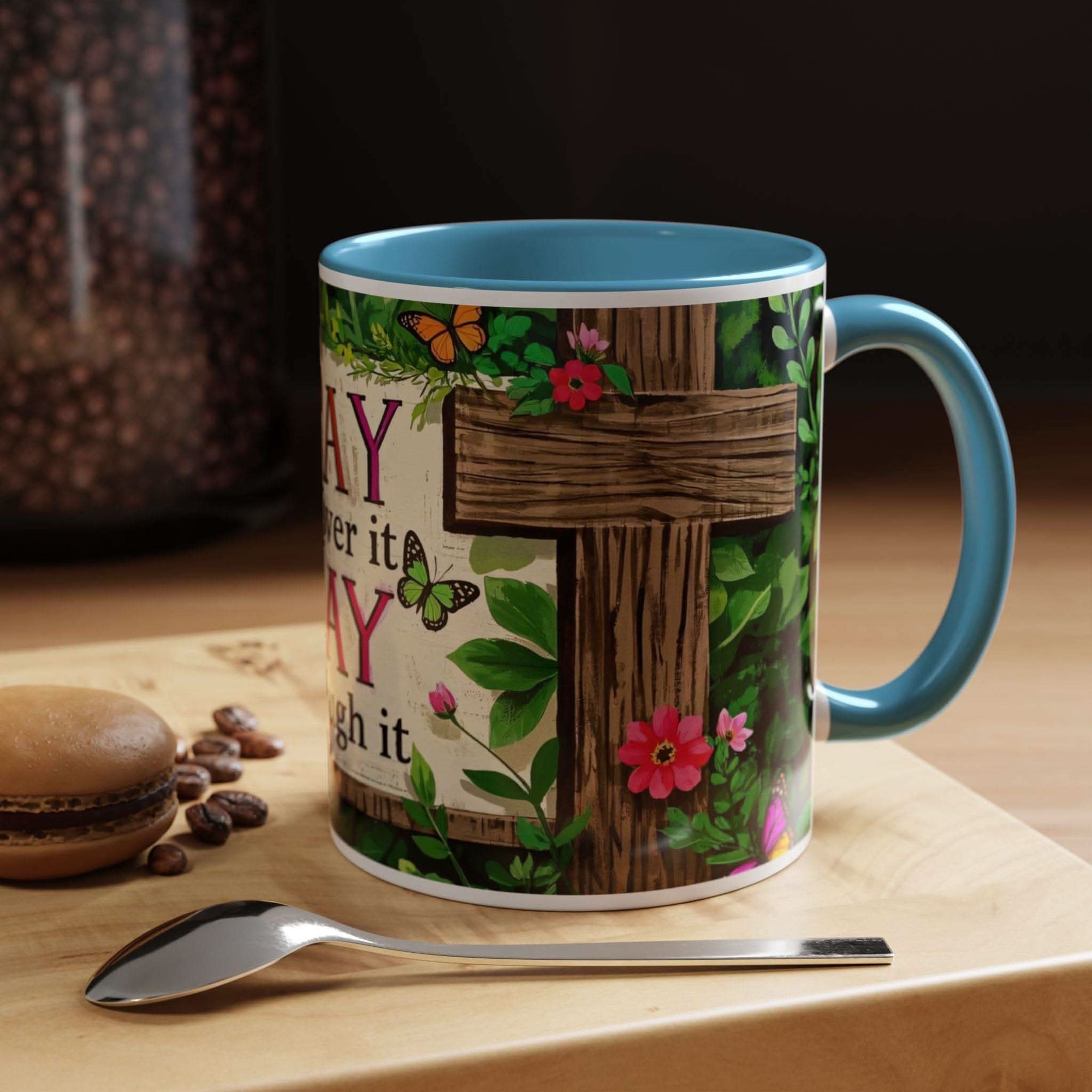 Mug with floral and butterfly design on a wooden surface with coffee beans and a spoon.