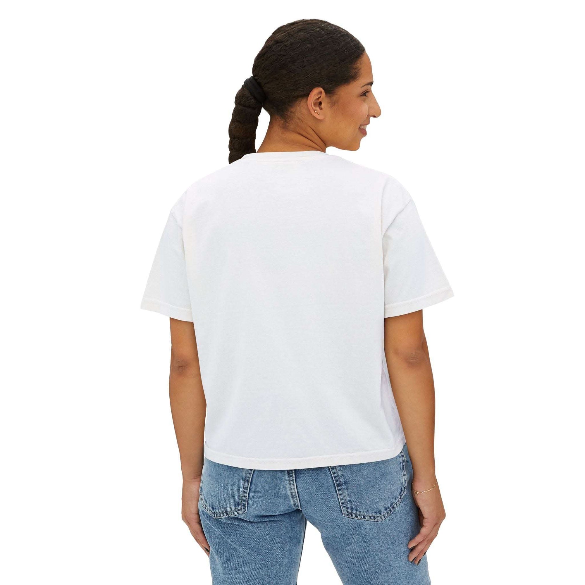 Woman wearing white boxy tee with short sleeves and cropped fit, paired with blue jeans, back view