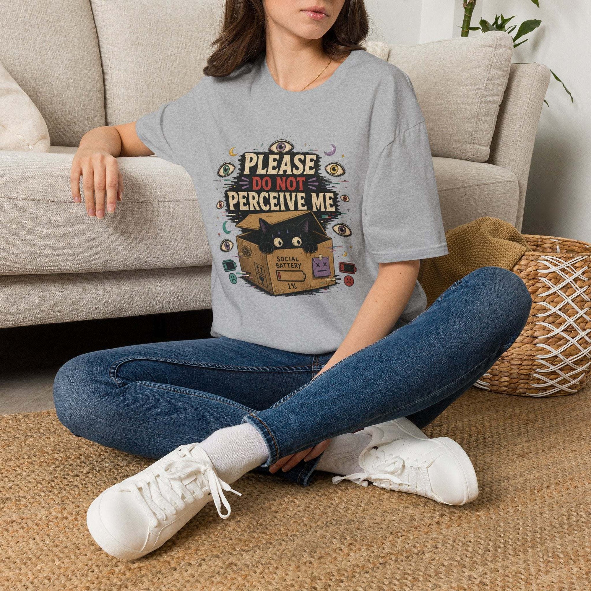 Black cat in box with "Please Do Not Perceive Me" text and occult symbols on surreal t-shirt