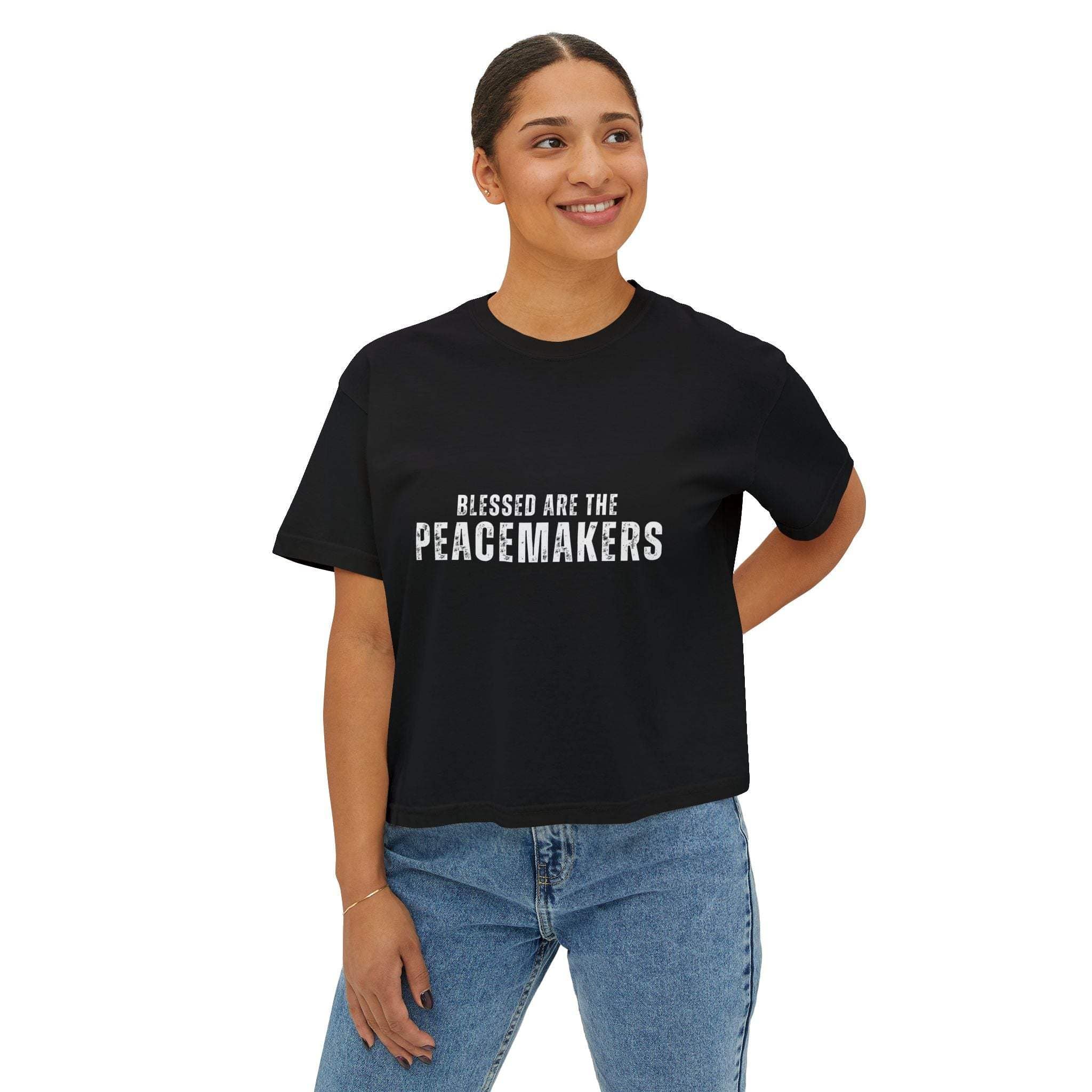 Women wearing black Tee Blessed be the Peacemakers boxy shirt with white text and jeans