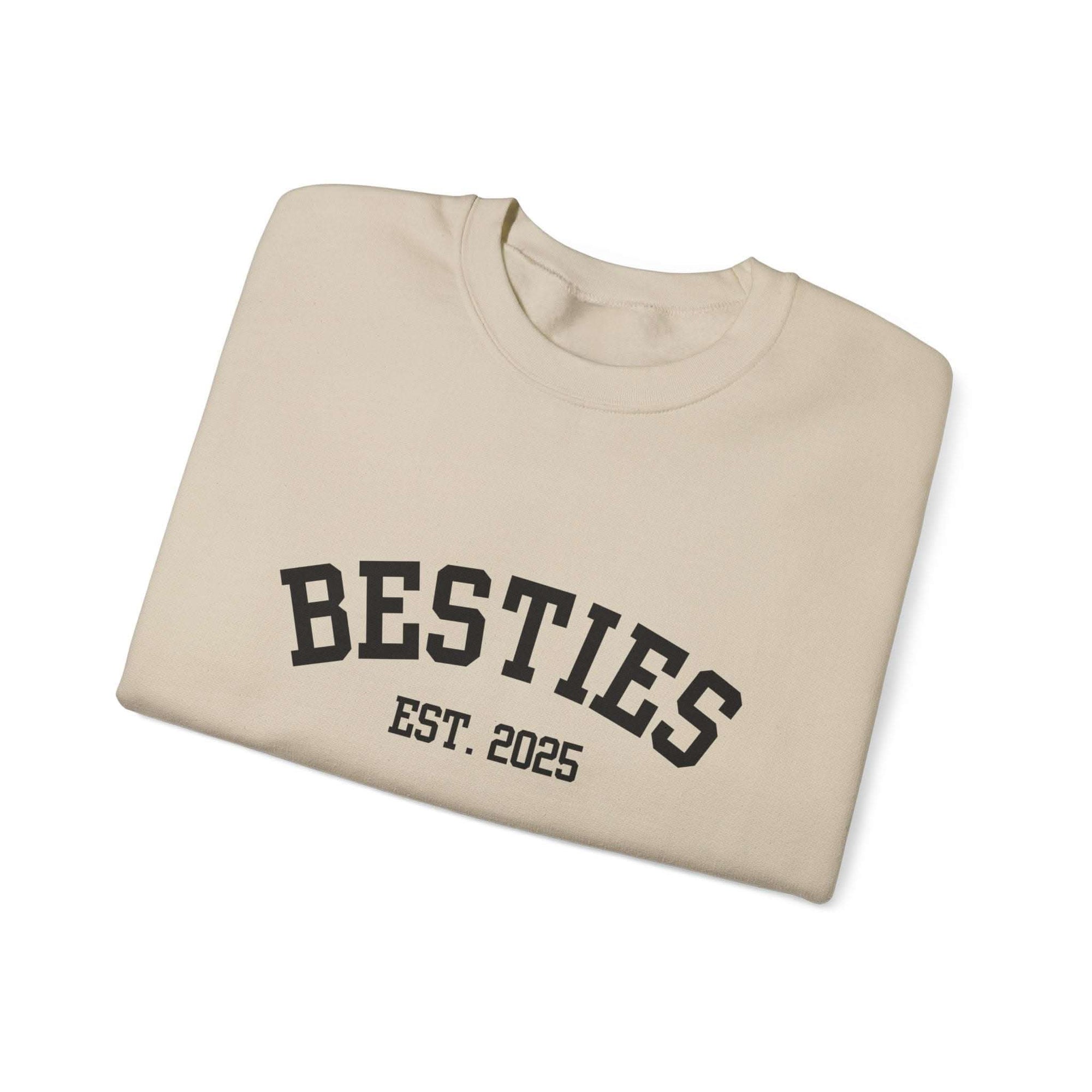 Beige sweatshirt with 'BESTIES EST. 2025' text on a white background