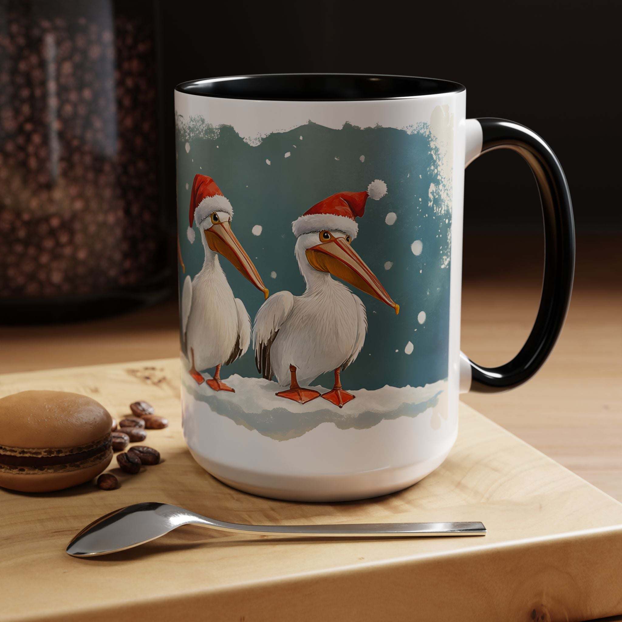 Mug with Christmas-themed design of two pelicans wearing hats on a wooden surface with coffee beans and a spoon.